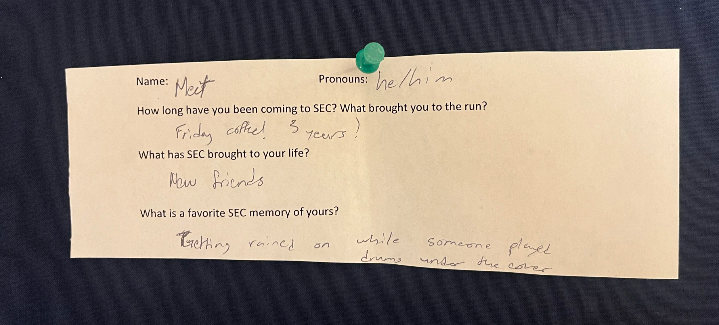 An image of a slip of white printer paper with typed questions and hand written answers. The paper is pinned to a navy blue background with a green thumbtack. The contents of the writing are written below the photo.