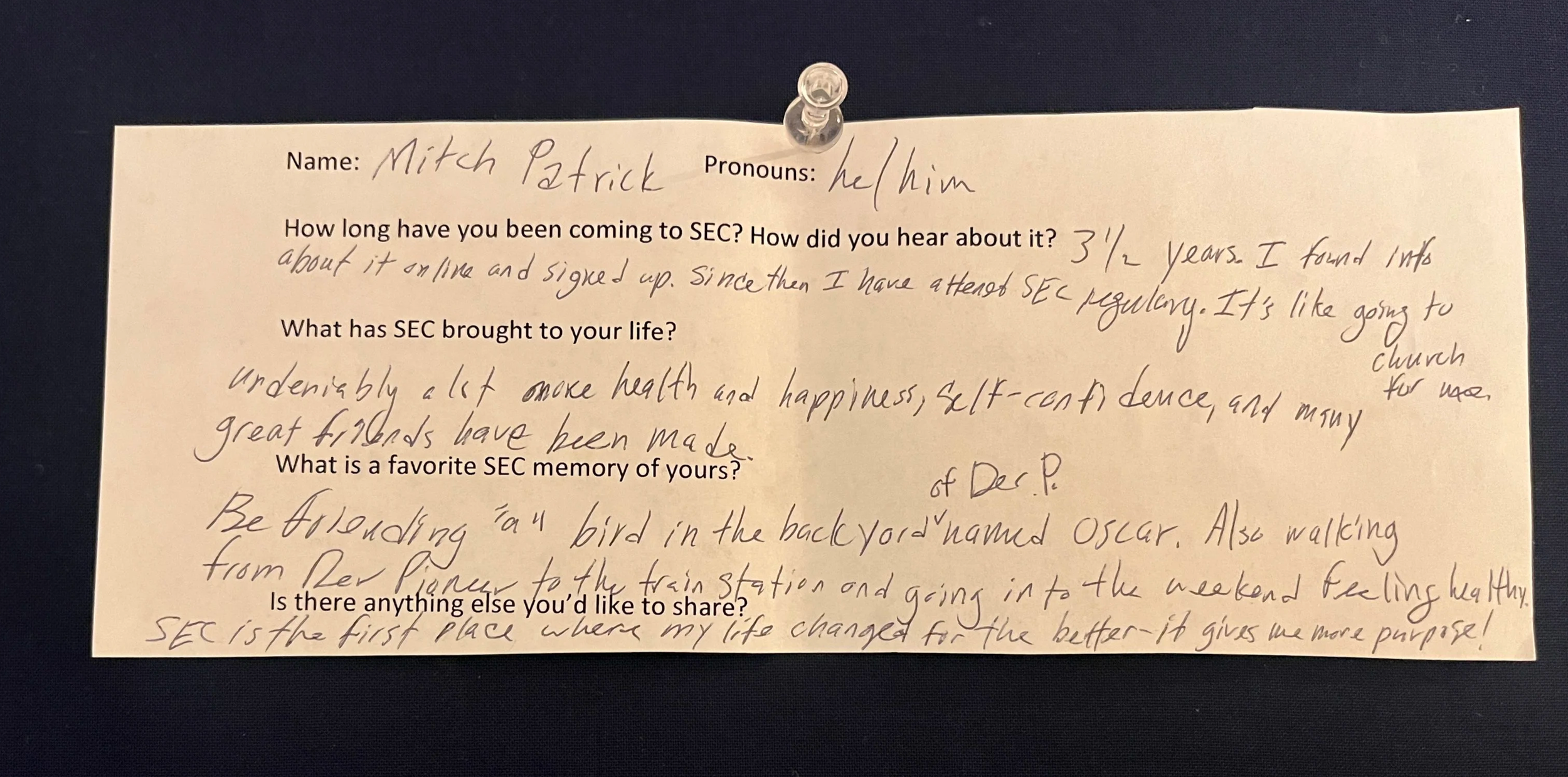 An image of a slip of paper with typed questions and hand written answers. The paper is pinned to a navy blue background with a clear thumbtack. The contents of the writing are written below the photo.