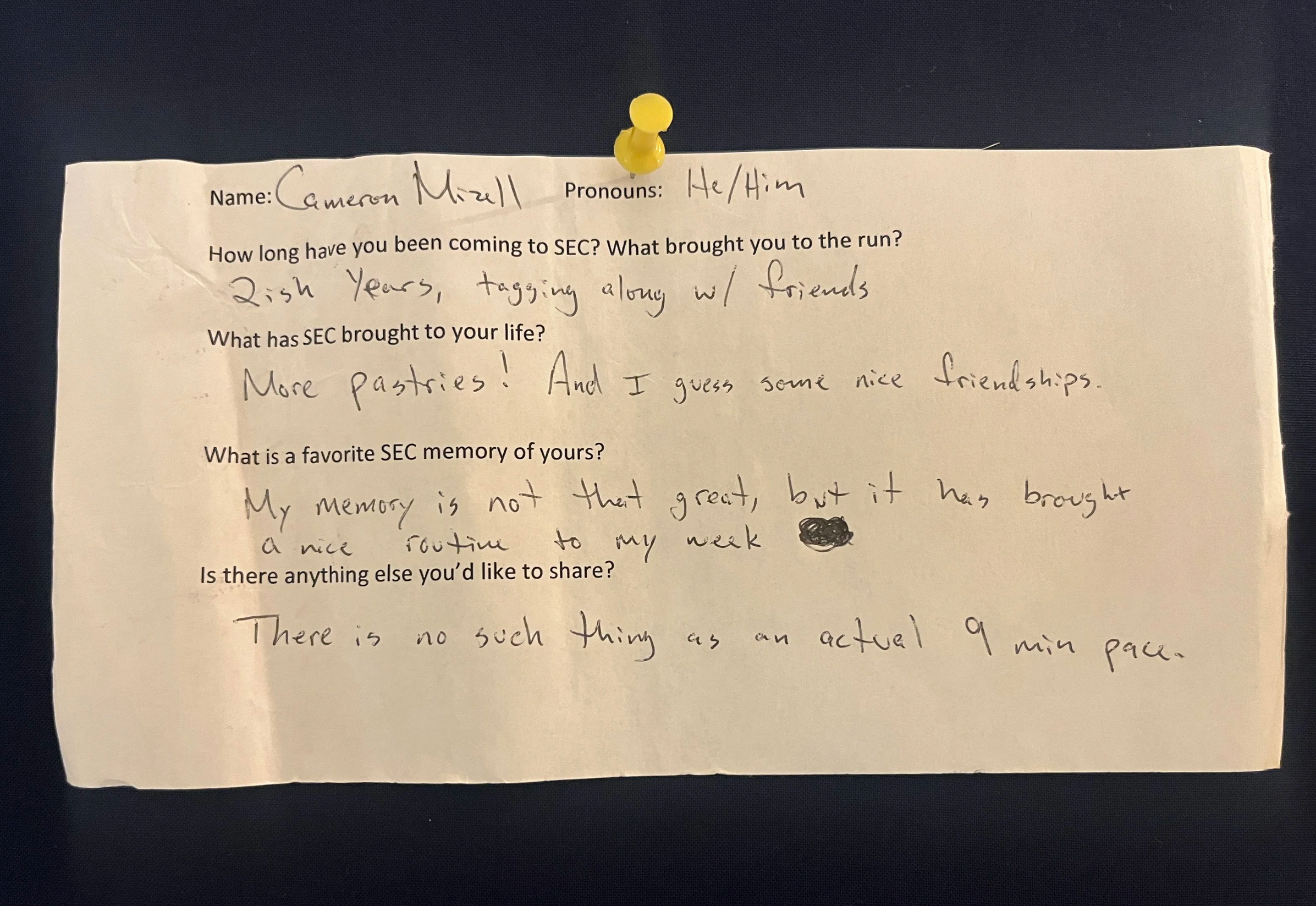 An image of a slip of paper with typed questions and hand written answers. The paper is pinned to a navy blue background with a yellow thumbtack. The contents of the writing are written below the photo.