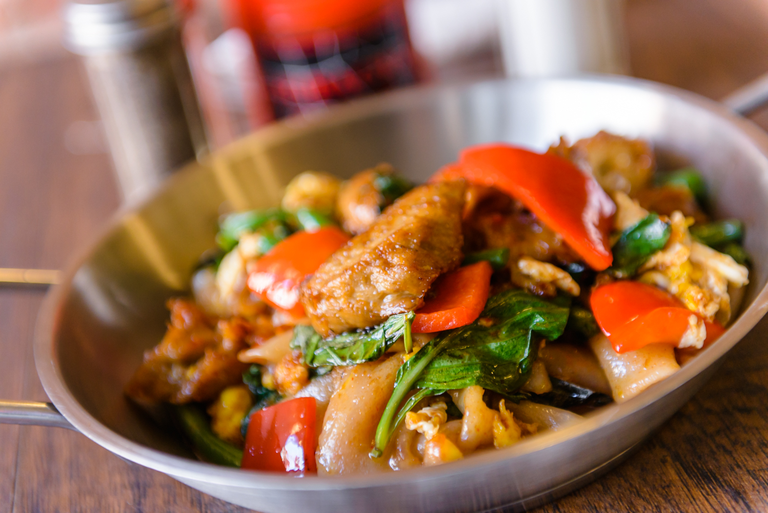 Sauteed Drunken Noodles served with flat noodles, spicy chili paste, basil, onion, bell pepper, and string beans