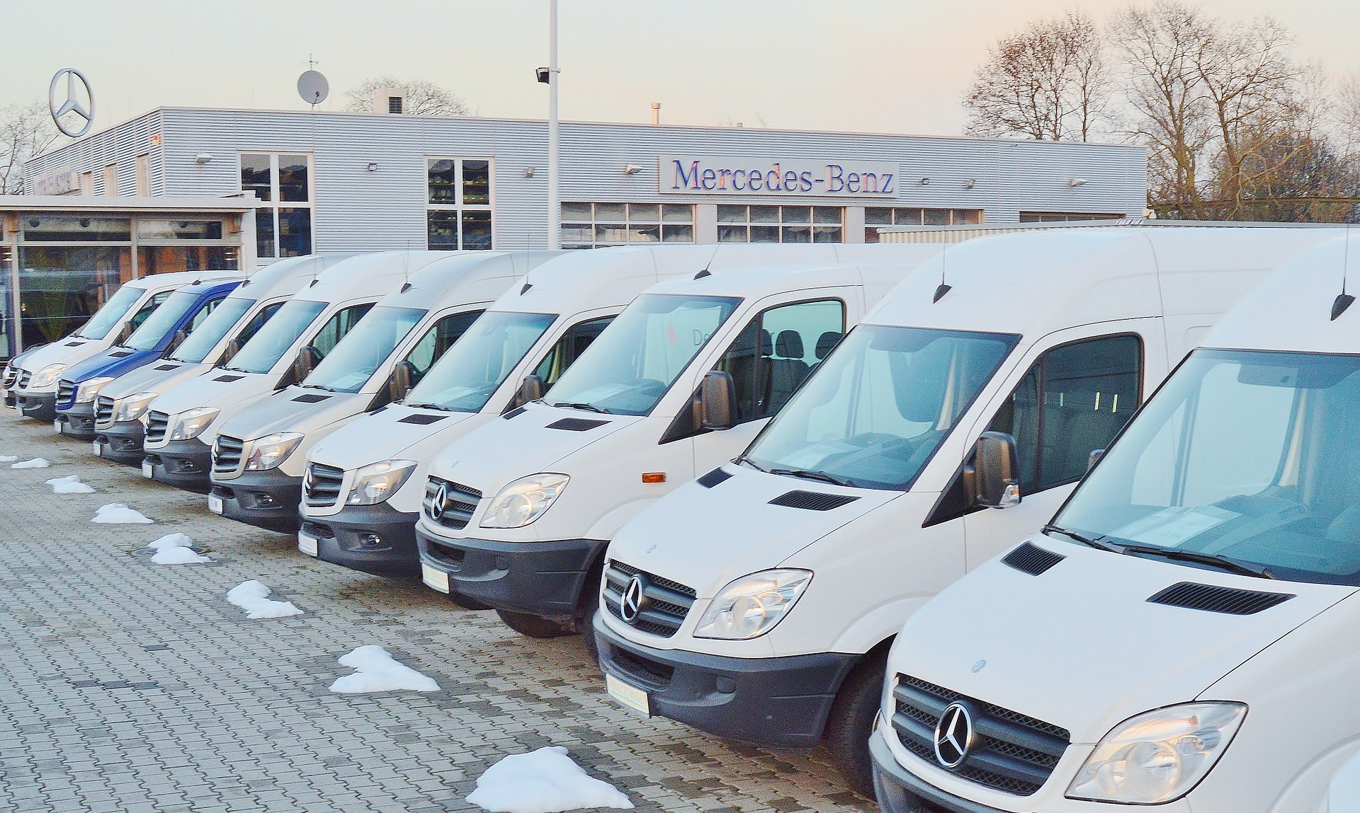  A fleet of white vans that are parked  