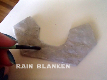 Poking the moist newspaper to create texture.