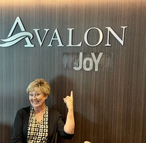 Joy Gawf-Crutchfield with the Avalon sign and Joy