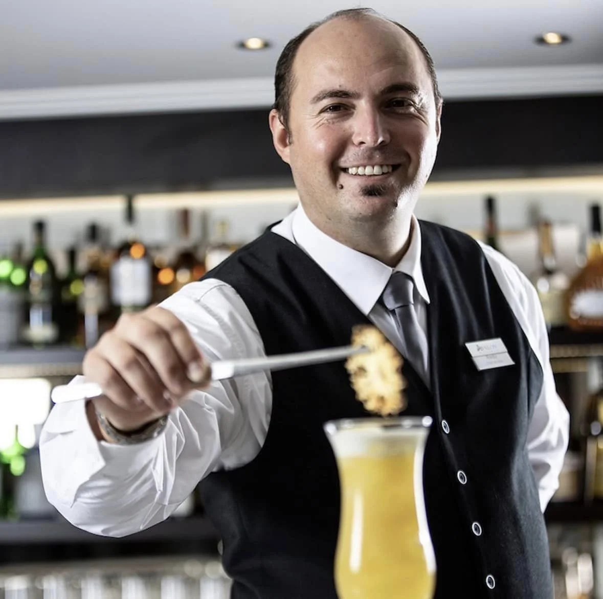 bar tender on river cruising ship making a fancy drink