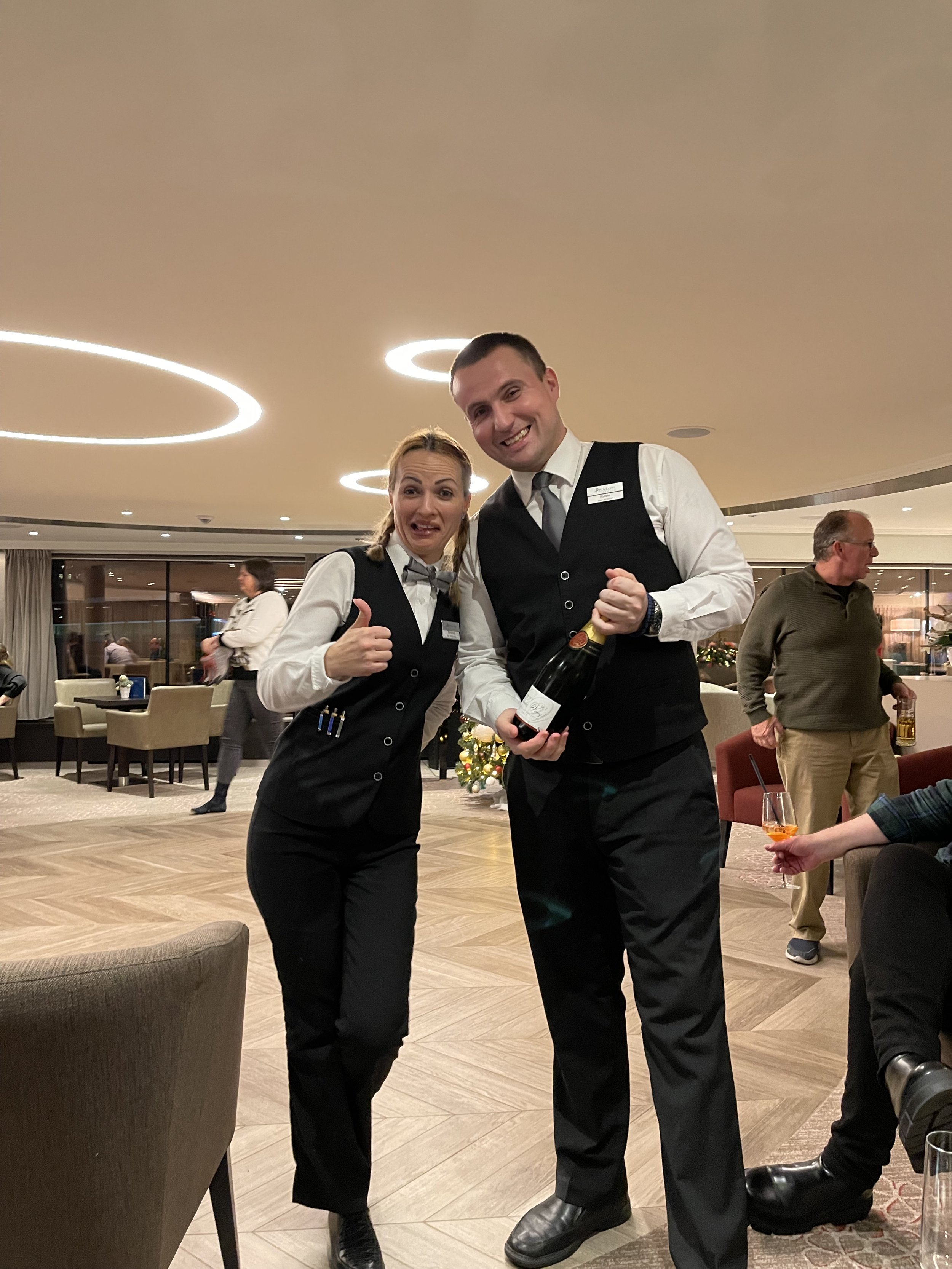 Two river cruising staff with a bottle of wine