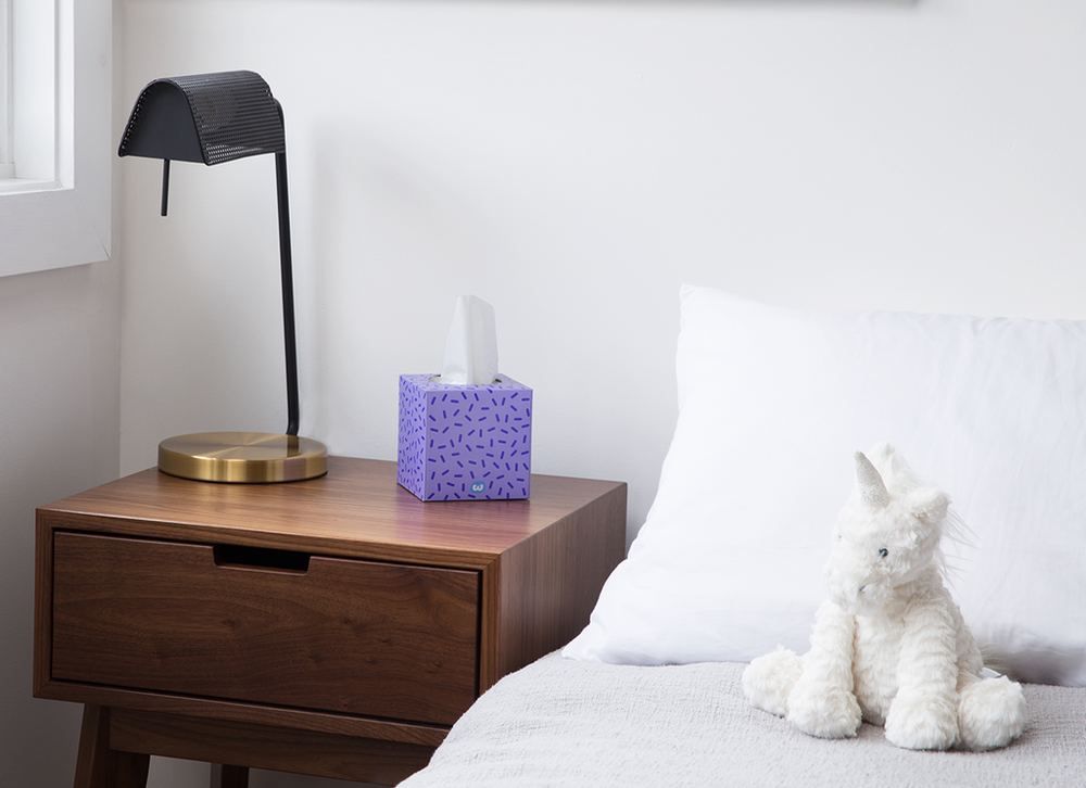 a bedroom with bedside table and lamp