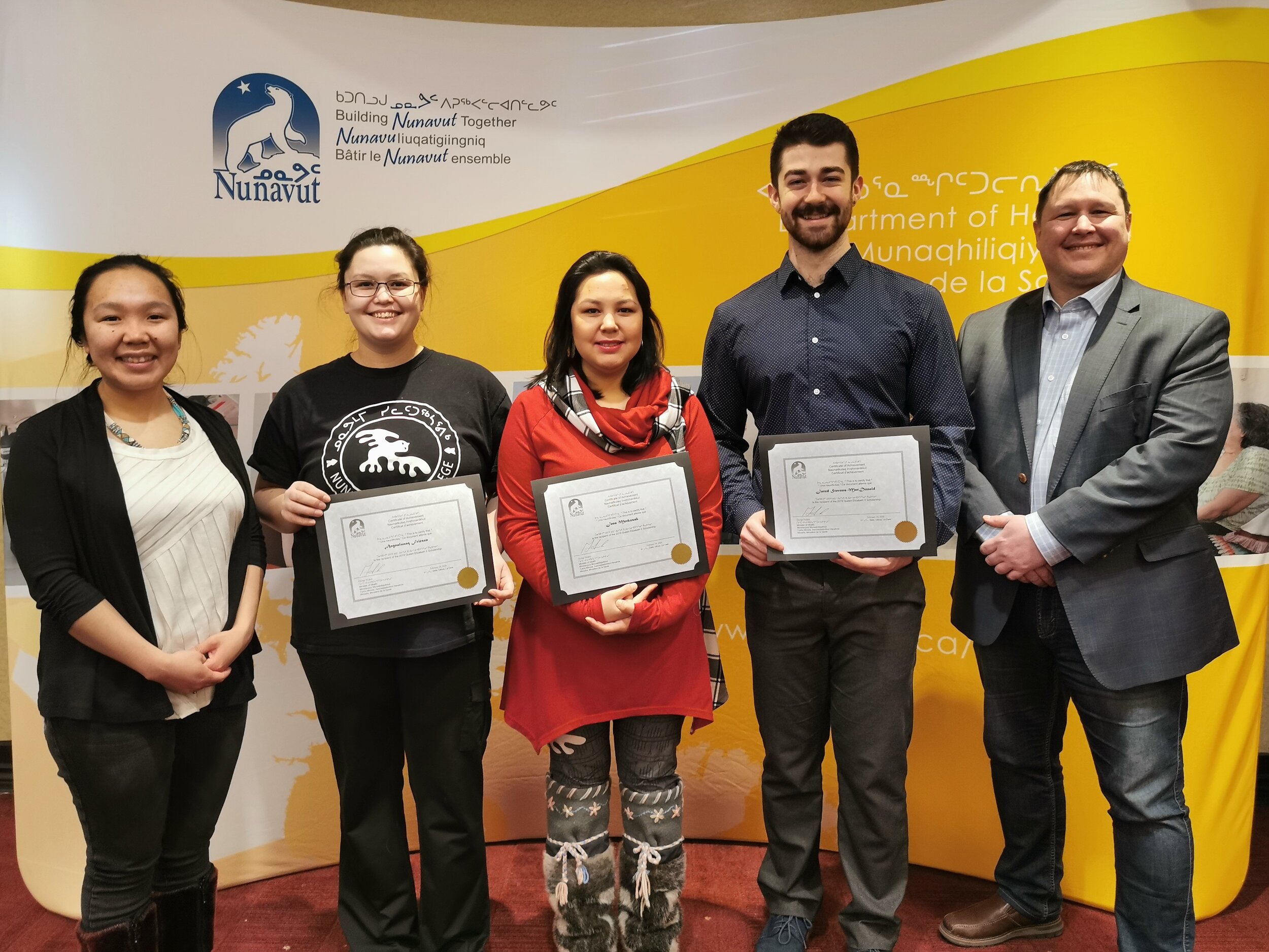   From left to right: Joanne Idlout, Agnaluak Fraisen, Jenna Merkosak, Jared Stevens-McDonald, Minister of Health, George Hickes. Not in the picture: Amy Clark, Amiel HErnandez and Sapatie Stokes.  