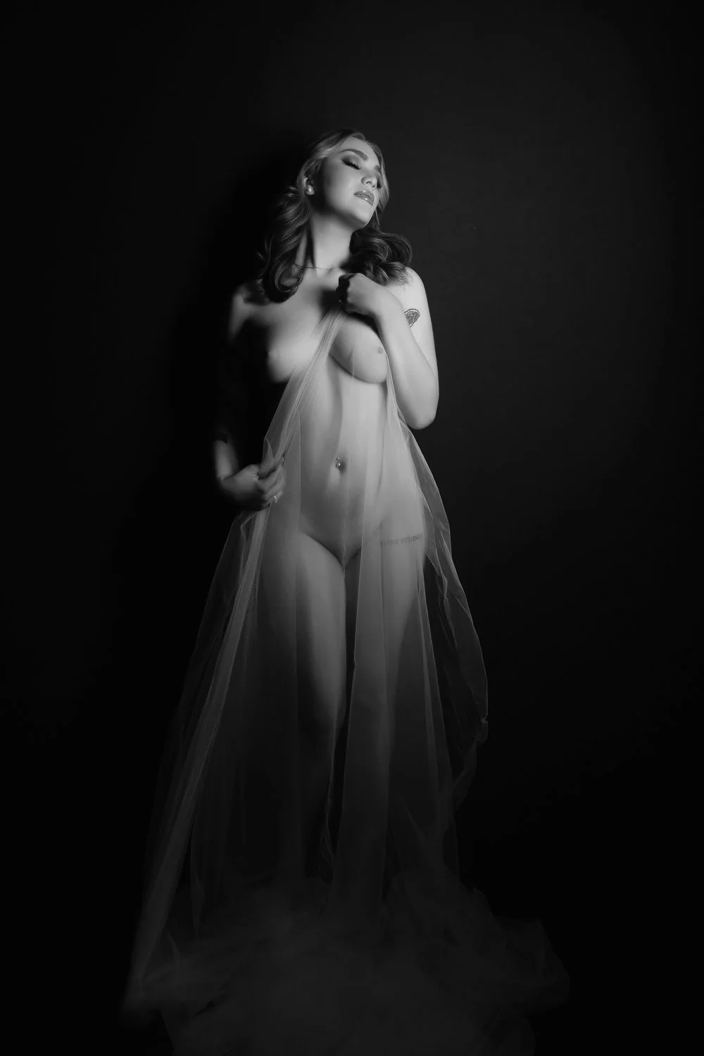 Woman posing with a bridal veil during a boudoir photoshoot