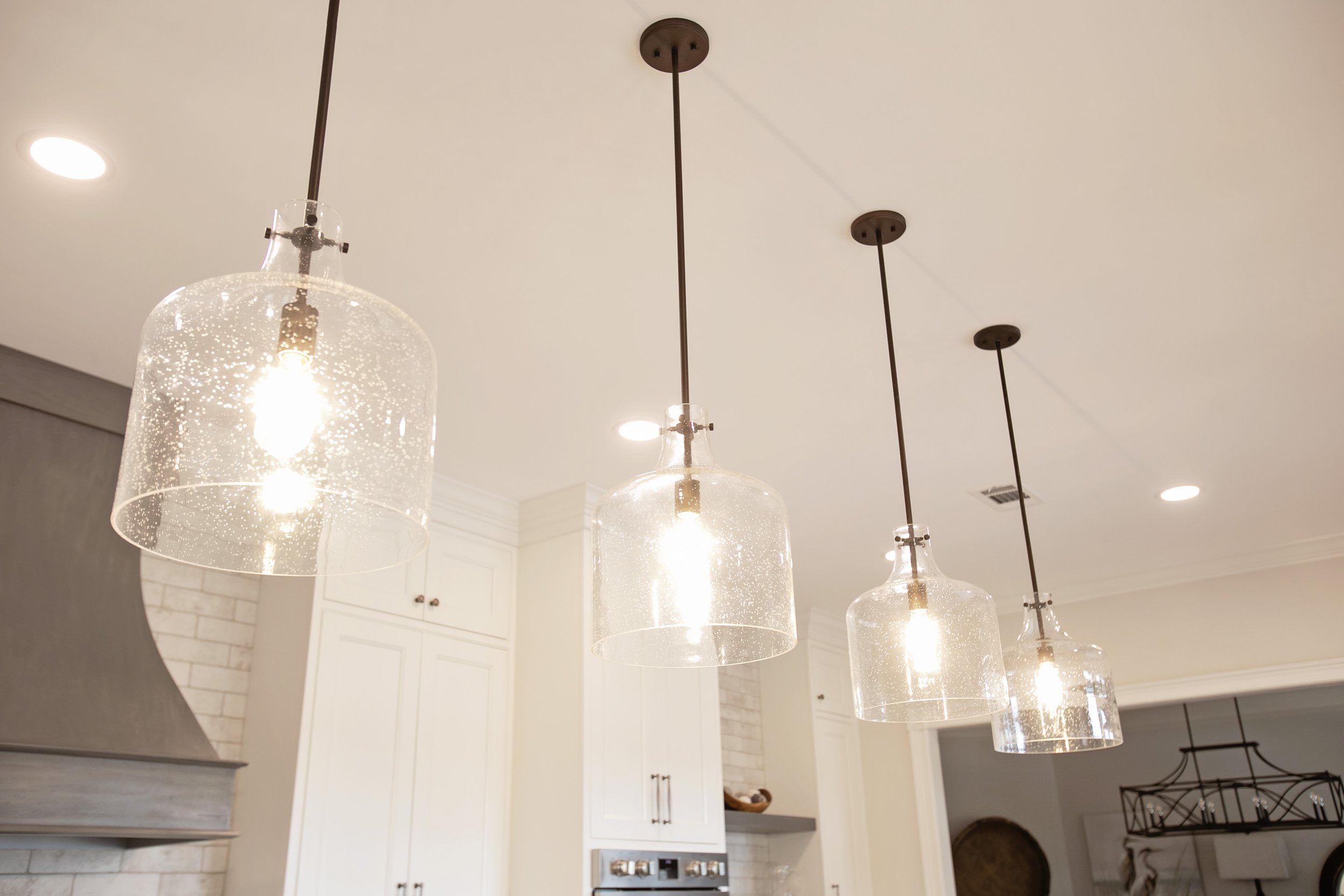 Four pendant lights over large kitchen island_Pool Brothers Lighting.jpg