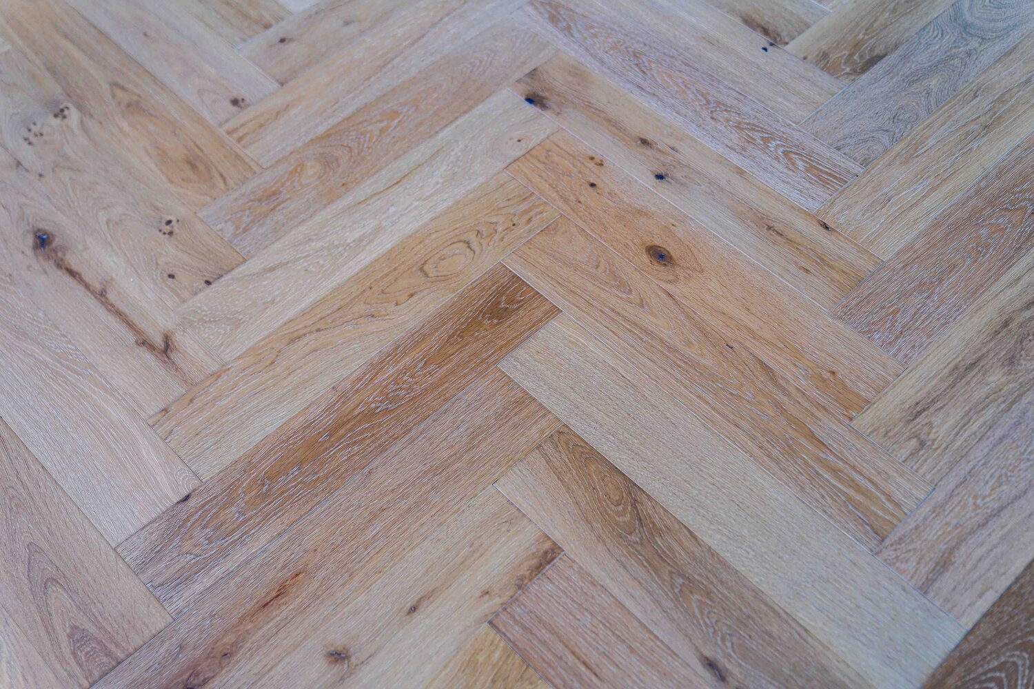 Light Colored Engineered Wood Floor in a Herringbone Pattern .jpeg