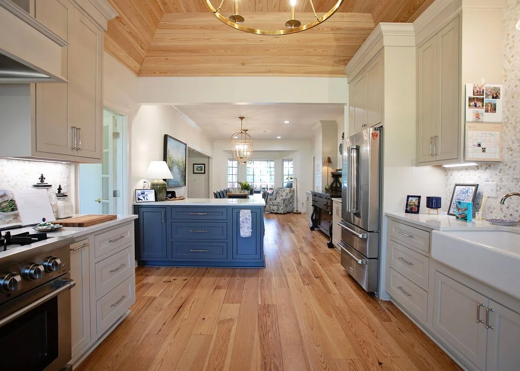 Heart pine wood flooring was installed throughout the kitchen, dining room, and adjoining living areas, then sanded, stained, and finished to create a warm, cohesive foundation across this River Pointe home in Albany, Georgia.