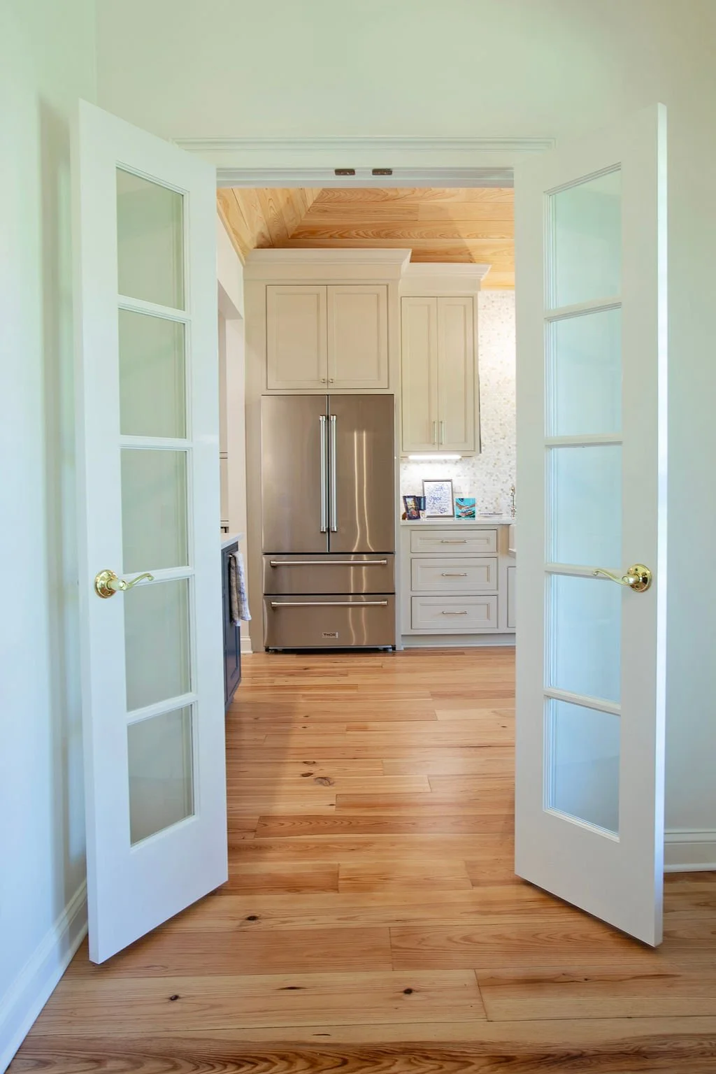  Heart pine wood flooring was installed throughout the kitchen, dining room, and adjoining living areas, then sanded, stained, and finished to create a warm, cohesive foundation across this home in Greensboro, Georgia. 