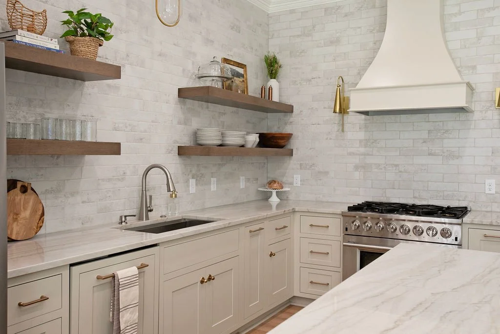 A beautiful kitchen with beige cabinetry and floating shelves finished in a light stain.