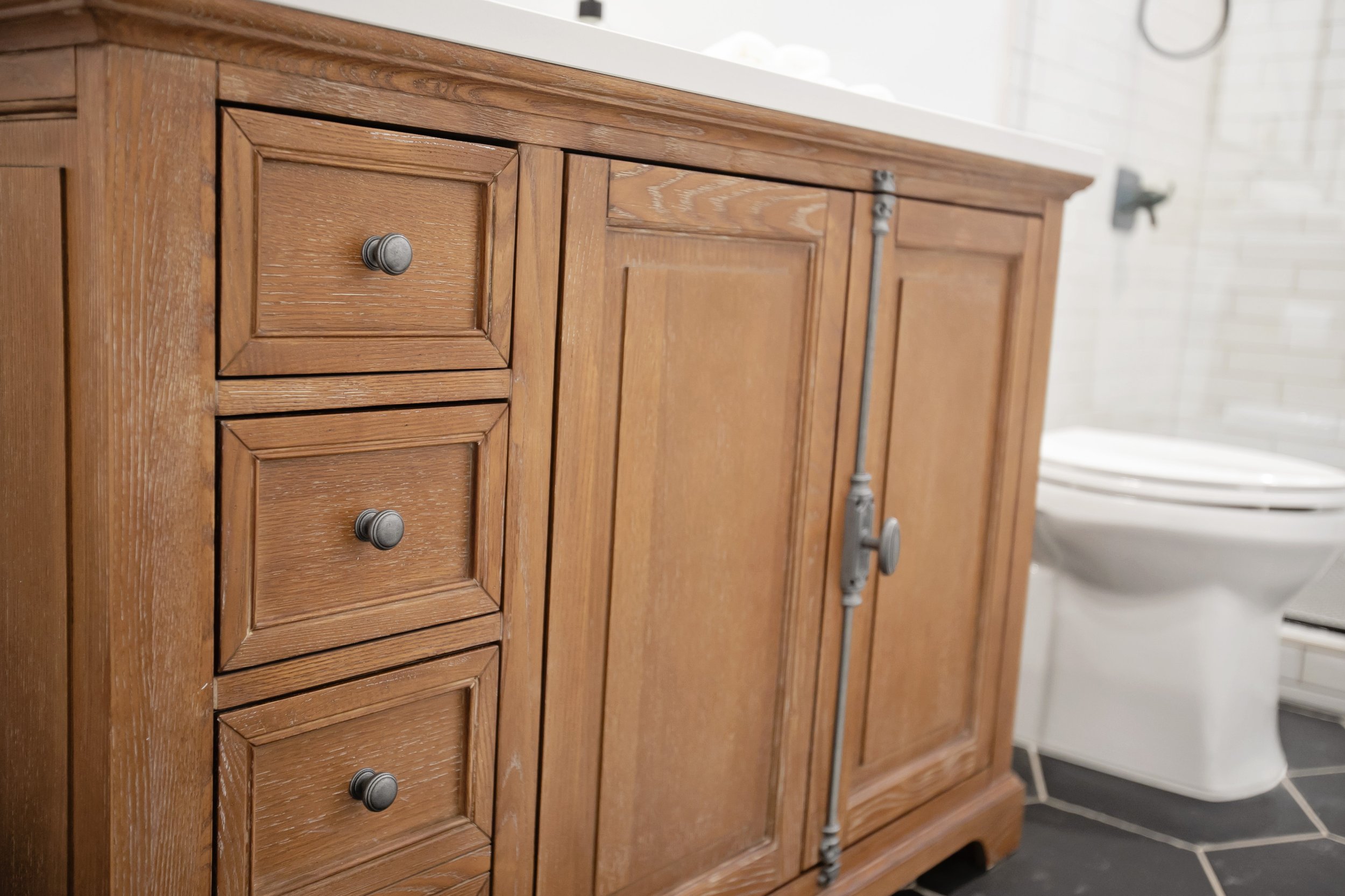 Stained Wood Vanity Cabinet with Antique Hardware by Pool Brothers Cabinets + Flooring + Lighting