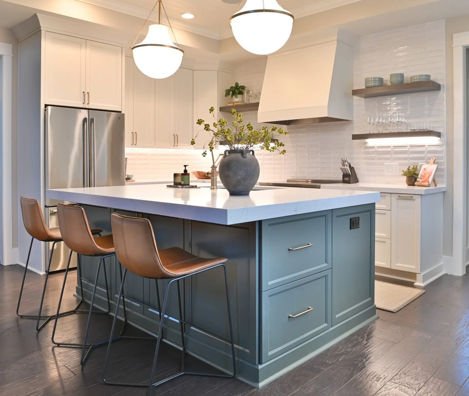 Luxury kitchen with Evergreen Fog island, white custom cabinets, quartz countertops, and hardwood flooring in Reynolds Lake Oconee, Greensboro, GA.
