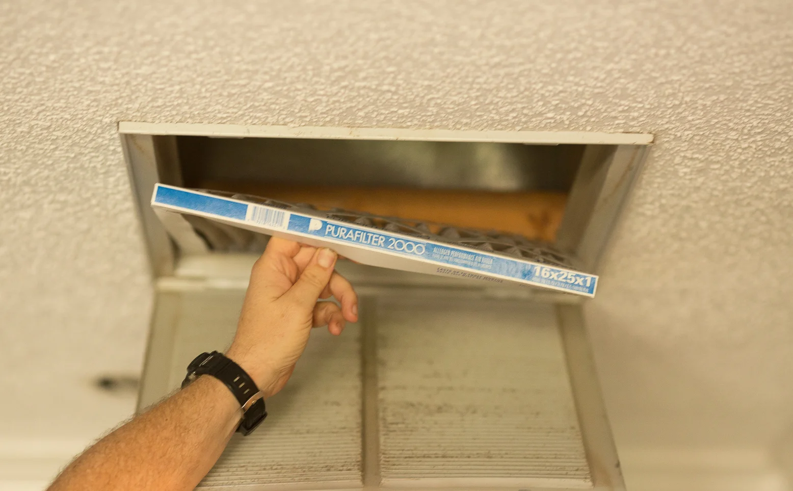 man changes filter on AC