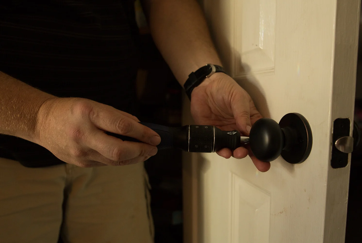 man changes home door lock