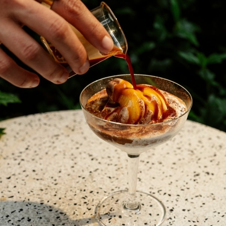 pessoa derramando café espresso sobre sorvete, preparando um affogato, sobremesa italiana no Futuro Refeitório