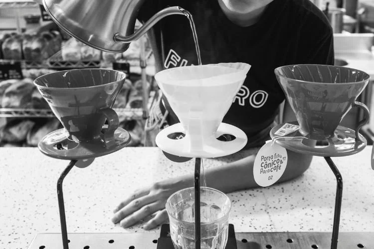 Pessoa filtrando cafés especiais no método V60 no Futuro Refeitório