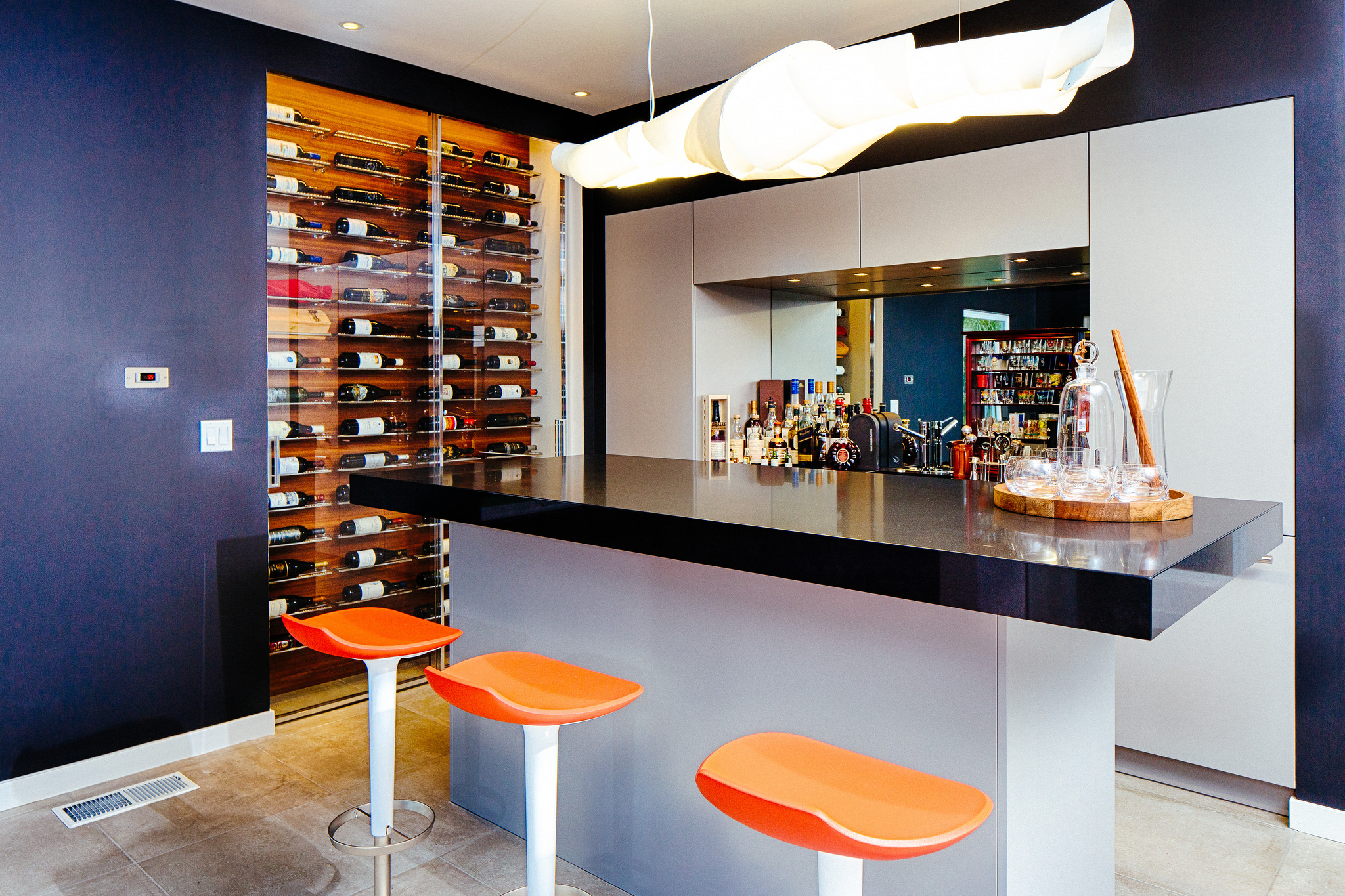 Bar area in ENTERTAINMENT center featuring a built in wine-cellar and custom designed cabinets.