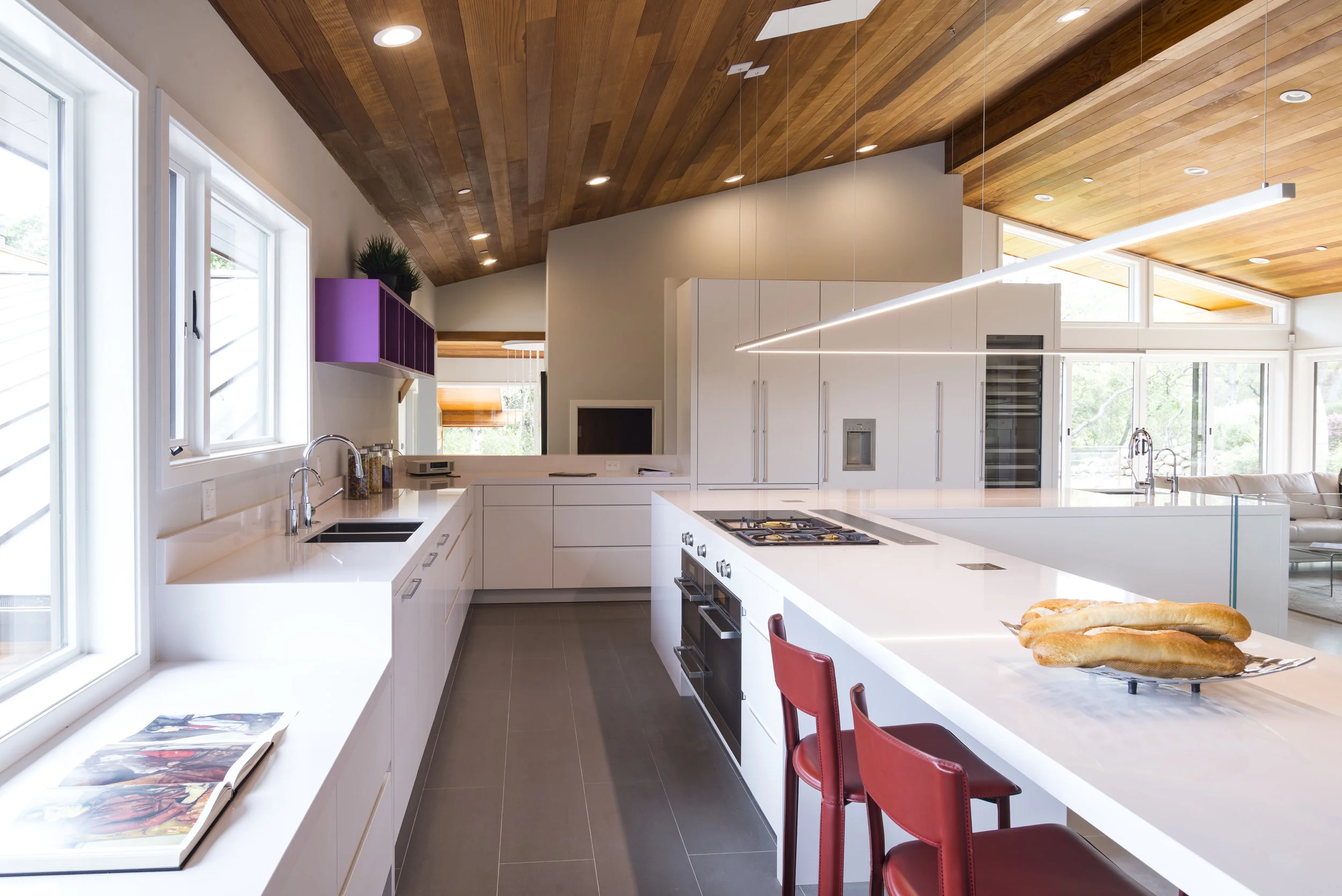 Due to the ceiling height, It was a challenge to light the kitchen countertop properly. We resolve it with a custom-made linear LED fixture that provides regular light to all the covers all the island.