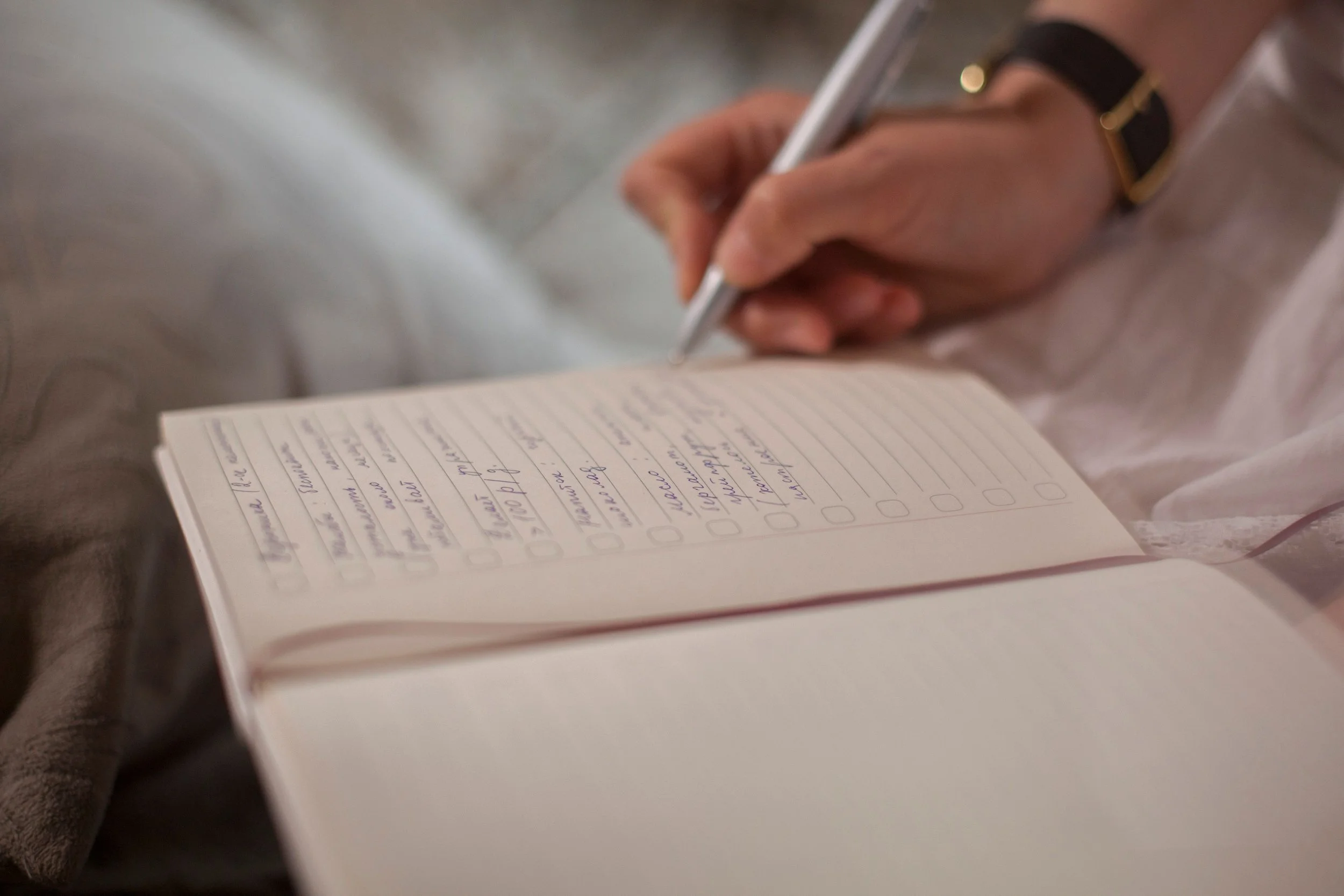 person writing in a planner, demonstrating routine.