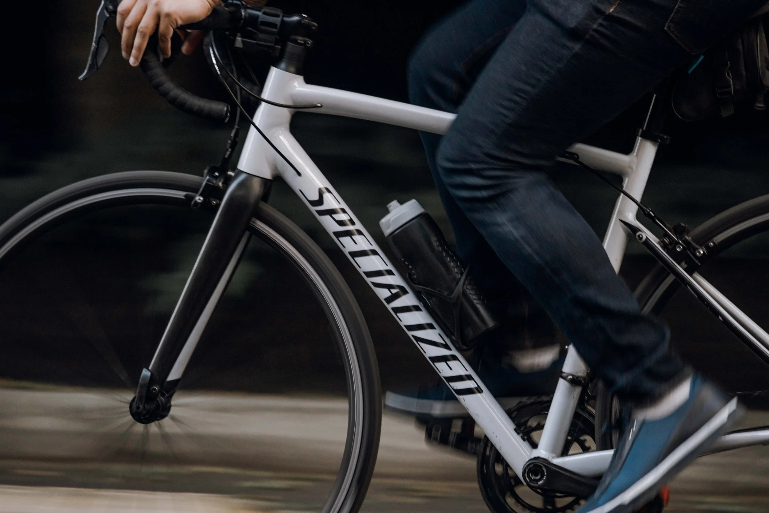 close-up of an adult riding a bicycle swiftly, using procedural memory to recall the movement.