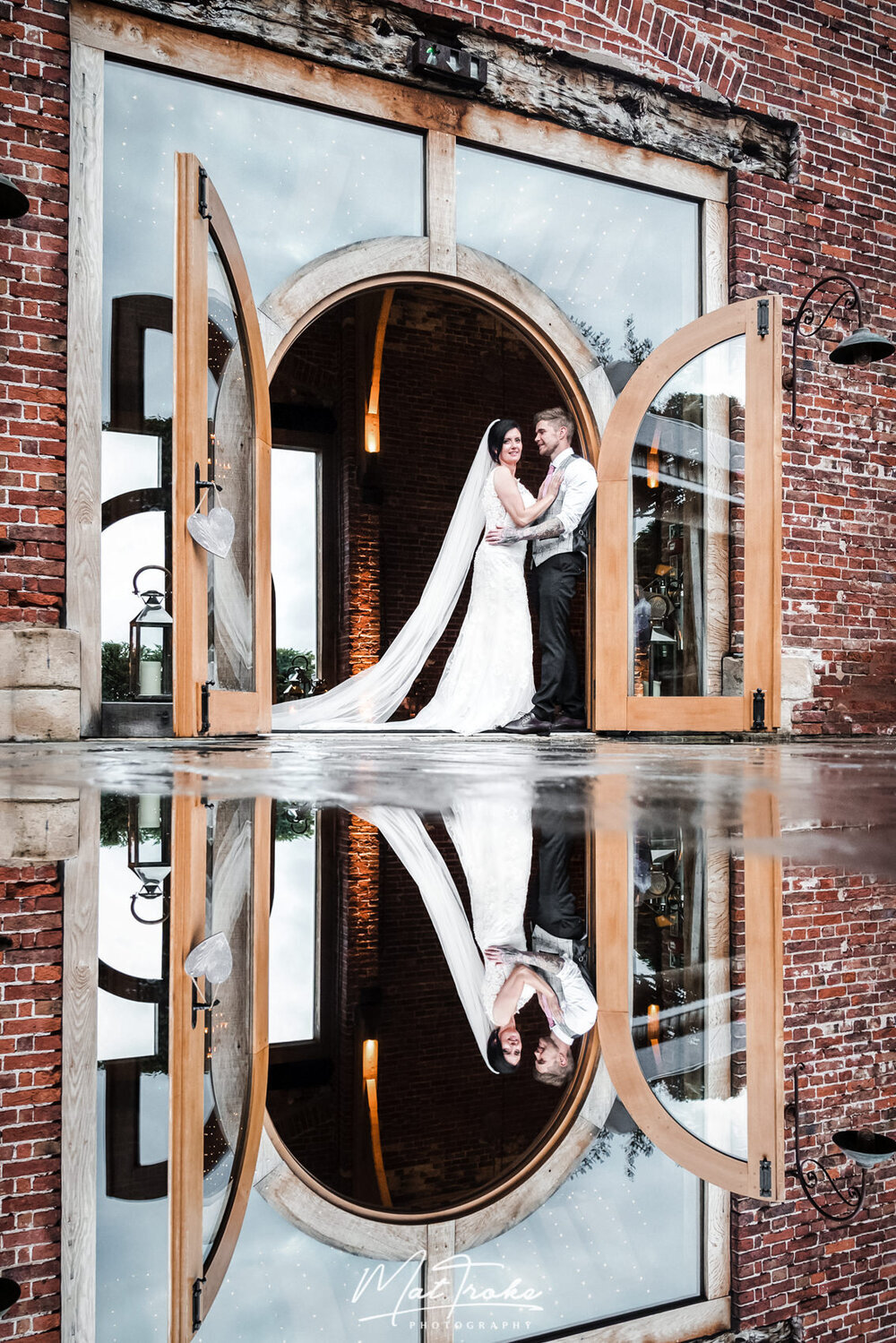 rainy-wedding-day-puddle-reflection-holding-just-married-wedding-ceremony-beautiful-bride-long-veil-hazel-gap-barn.jpeg