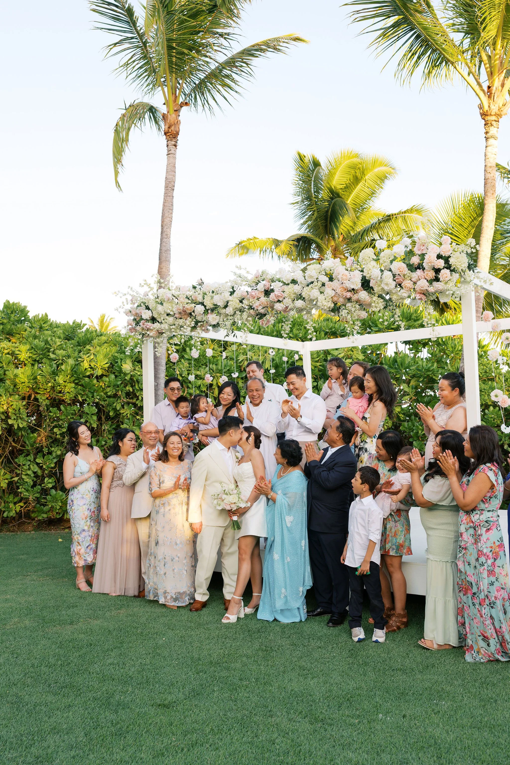 Family portrait under floral ceremony arch at Kaimea Estate wedding in Oahu