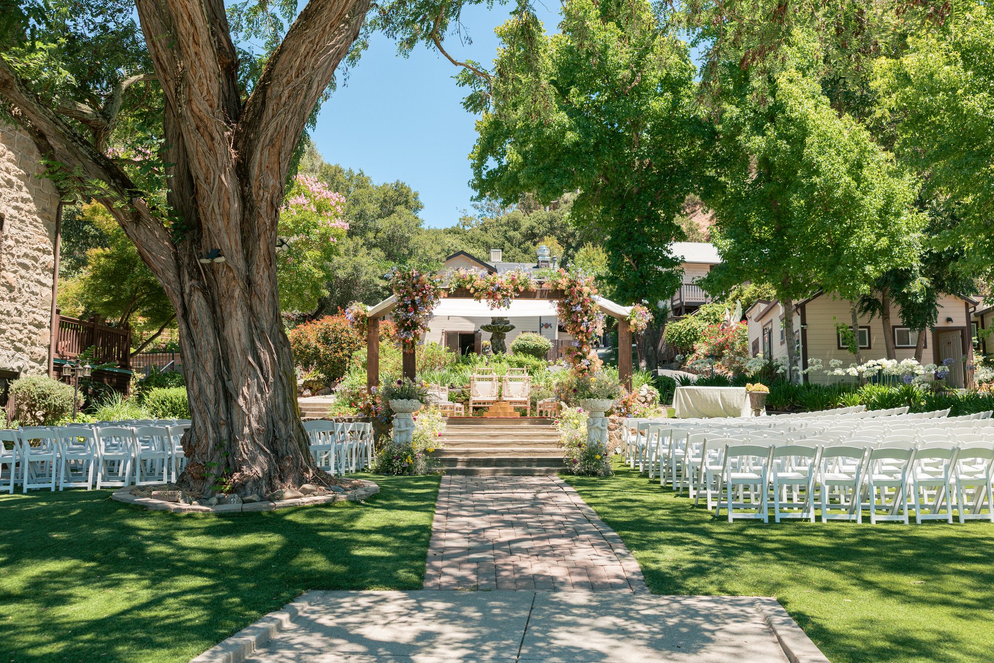 Traditional Indian wedding ceremony setup at Elliston Vineyards in the Bay Area with a floral mandap and outdoor garden aisle.