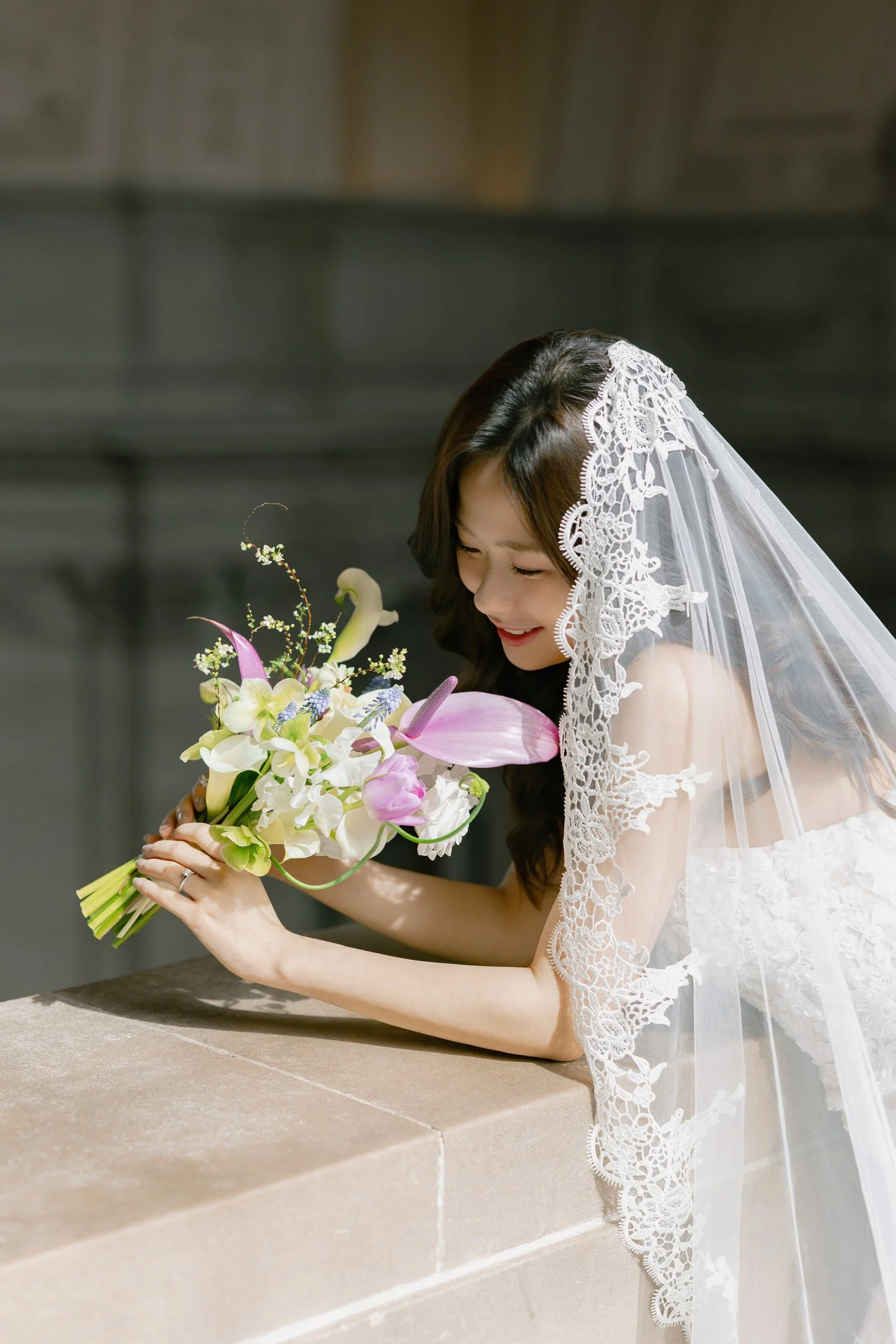 Bride holding a soft floral bouquet in natural light at San Francisco City Hall