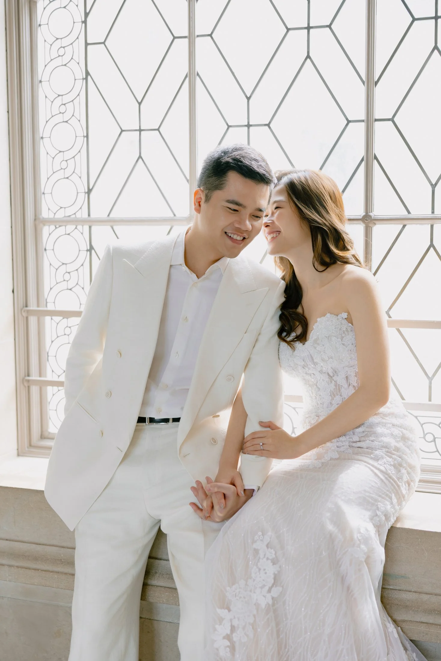 Couple portrait with geometric window details at San Francisco City Hall