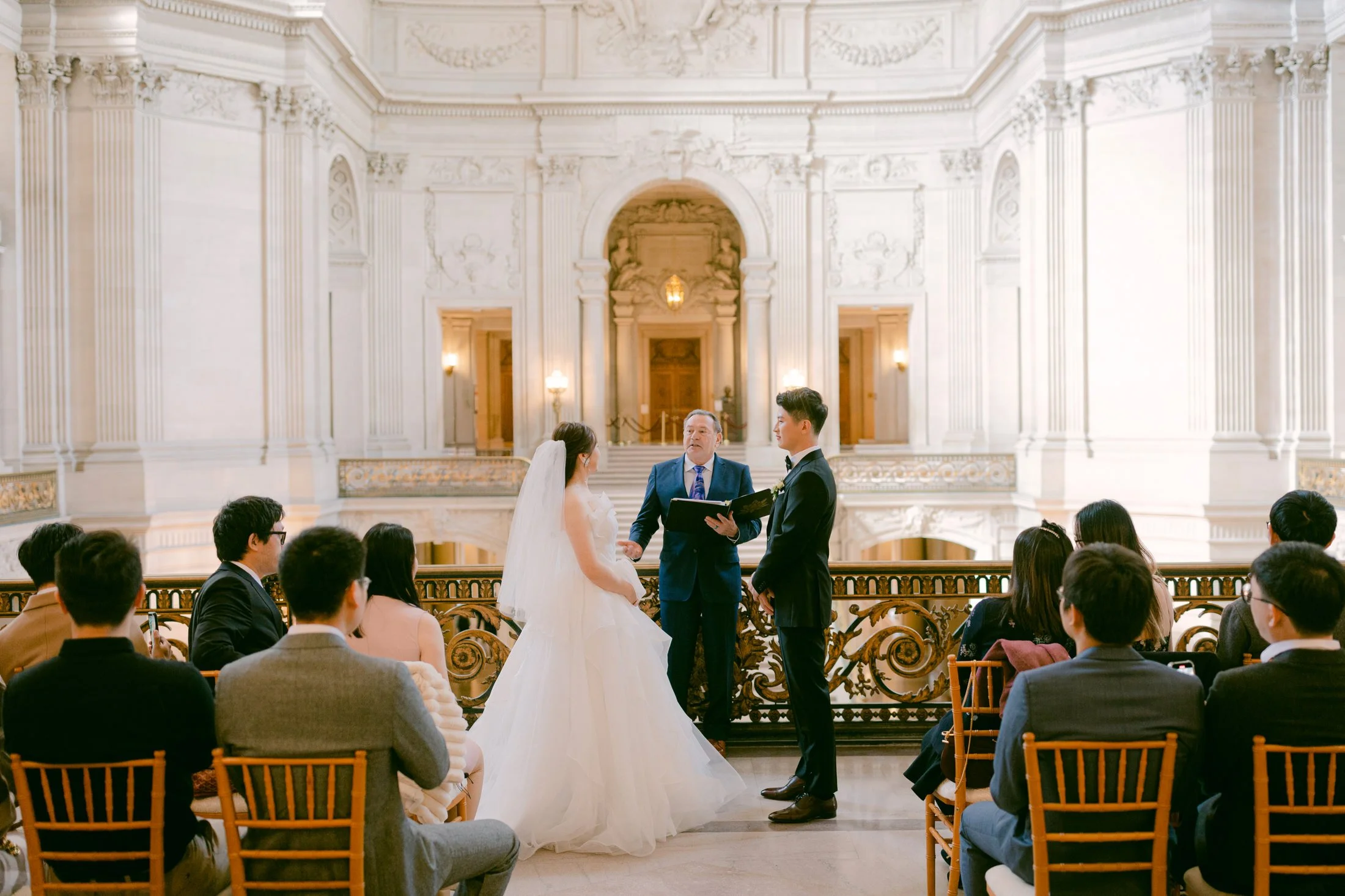 Wedding ceremony on the Mayor's Balcony at San Francisco City Hall second floor, with officiant and seated guests