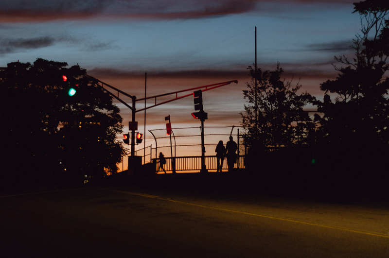 Two people on a bridge next to an intersection in sunset, Boston, MA