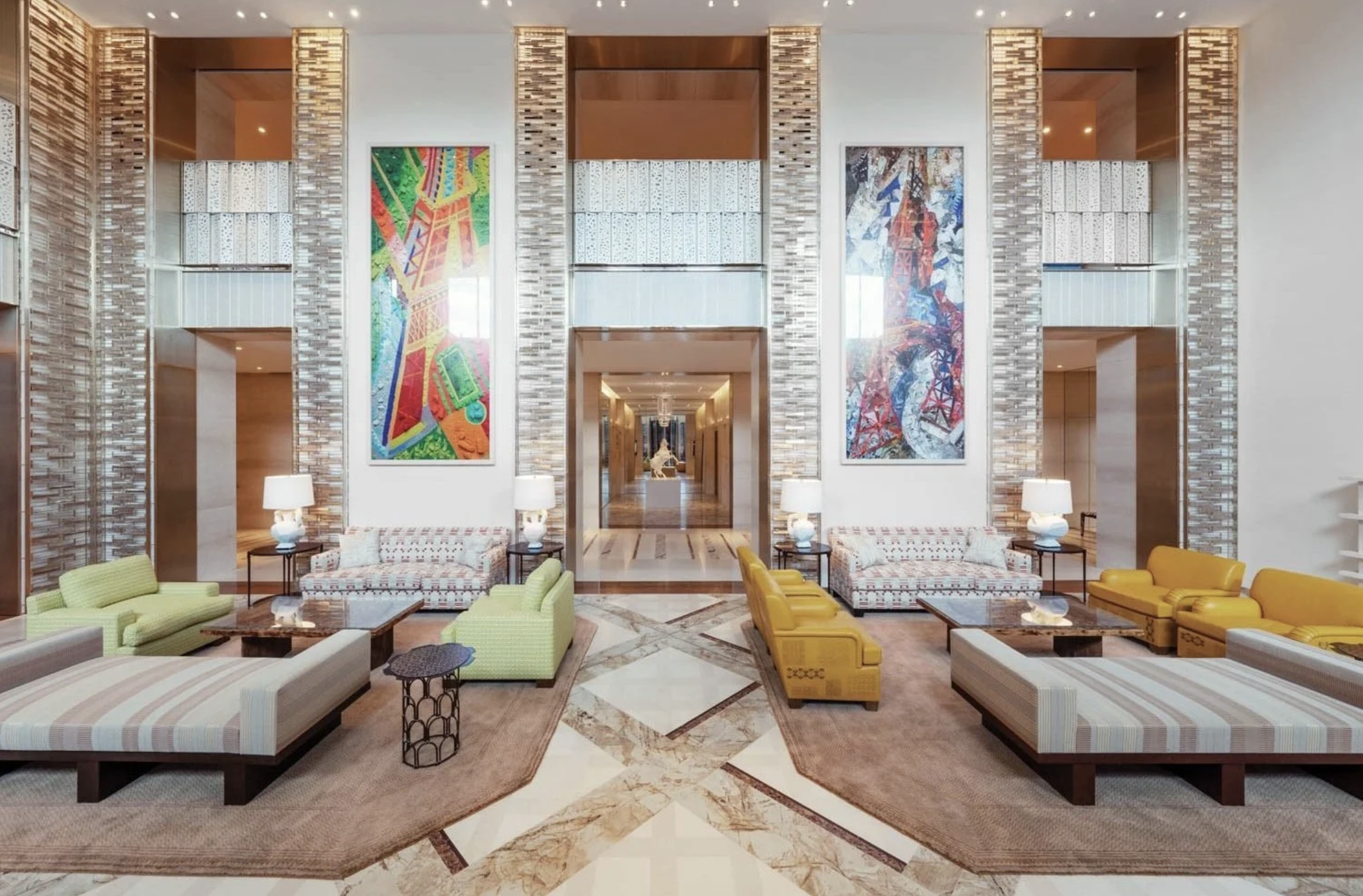 Grand hotel Lobby with tall ceilings, large scale art work and structured seating.