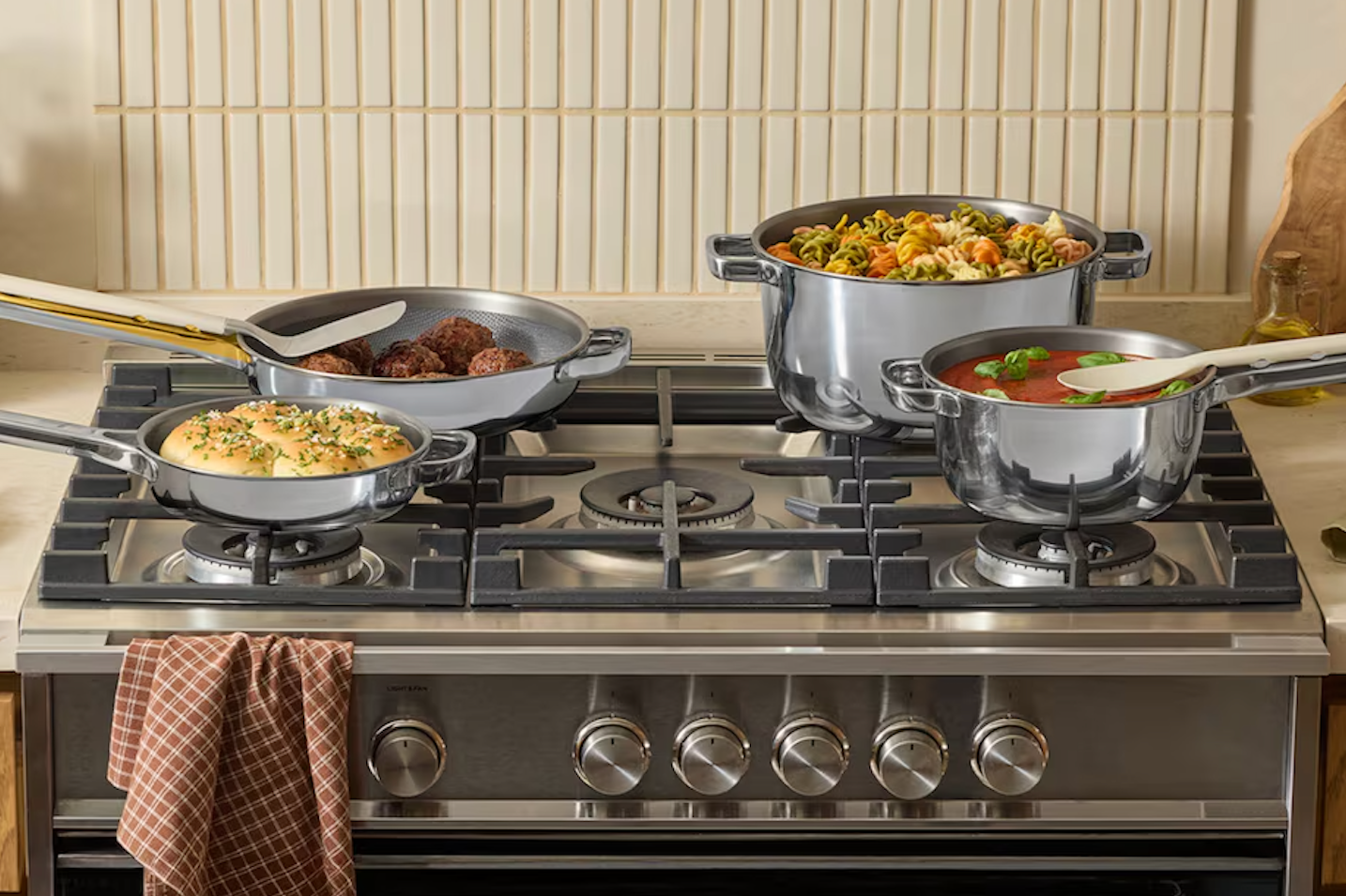 Our Place Titanium Pro cookware with gold handles styled on a modern stovetop kitchen