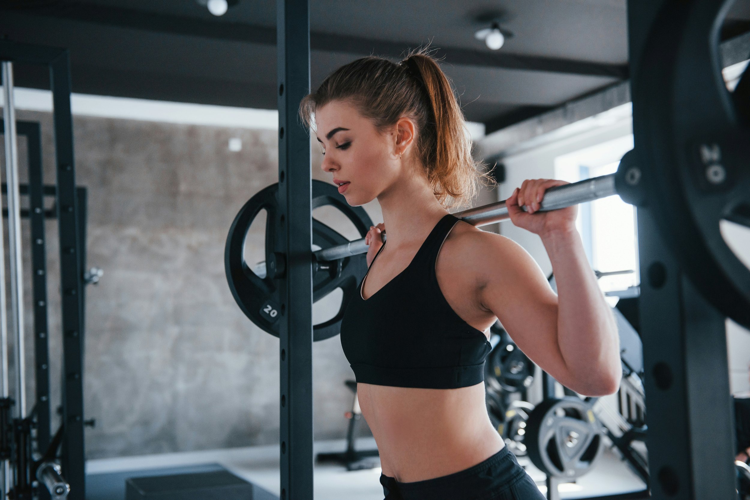 Woman strength training with a barbell in the gym