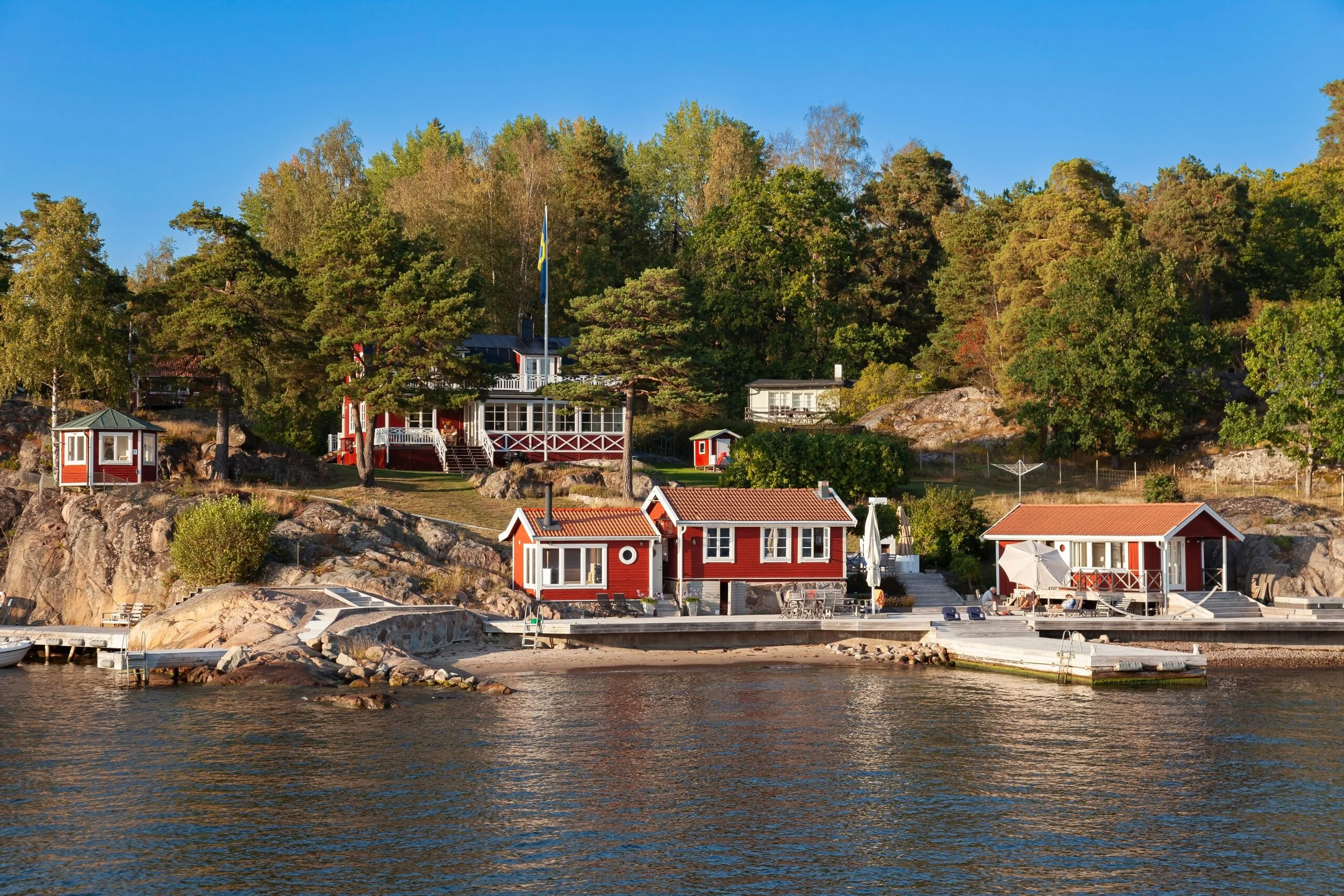 Red Scandinavian summer cabins beside the water in the Swedish archipelago