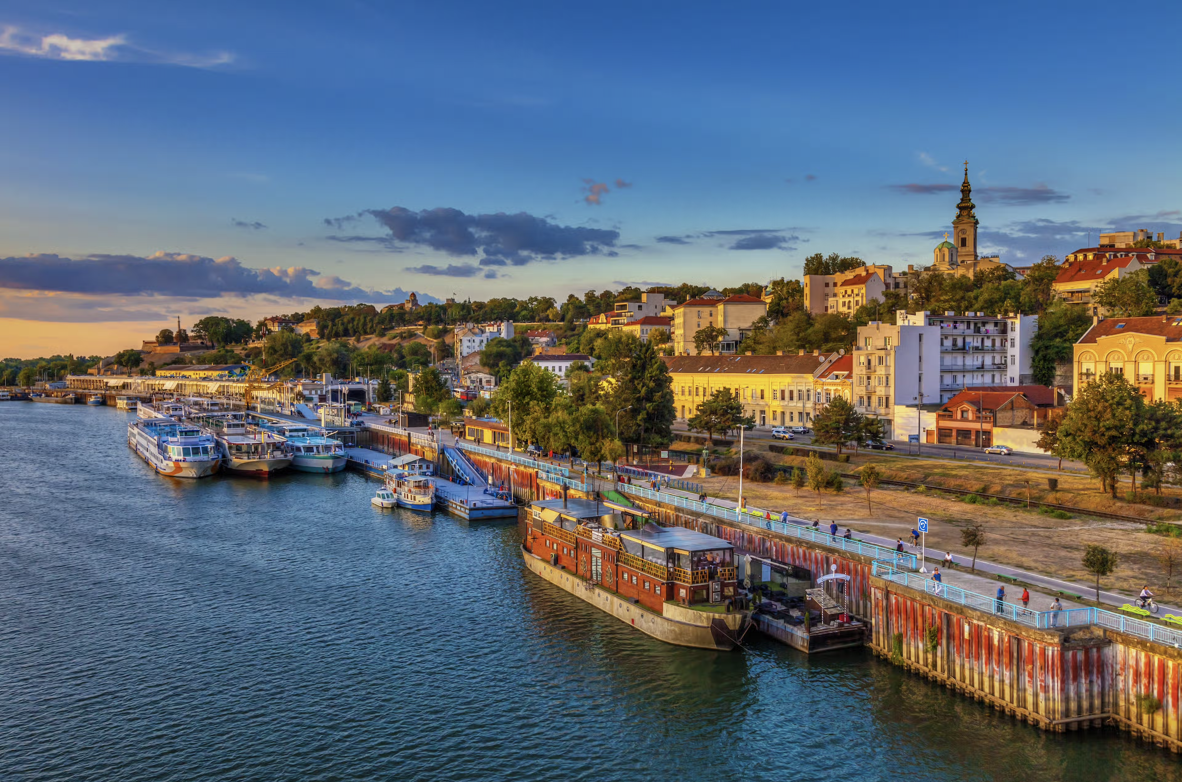 Belgrade, Serbia skyline at sunset with riverboats on the Danube and historic city buildings