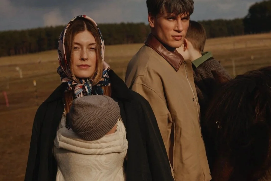 Stylish parents carrying their babies in Artipoppe baby carriers during an outdoor family walk