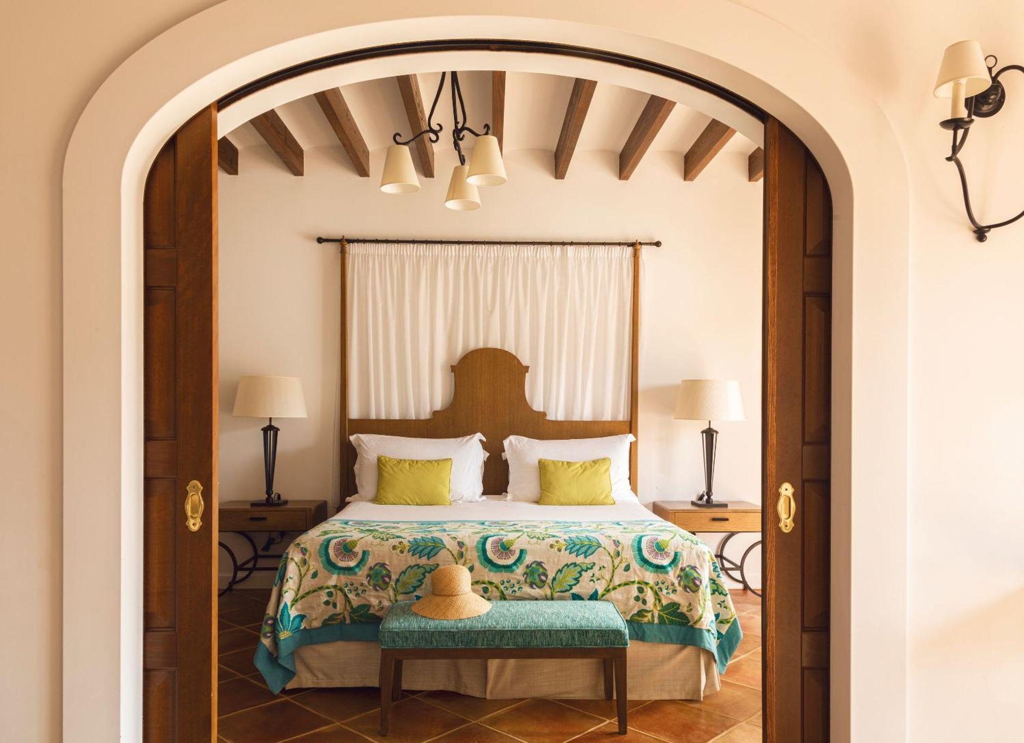 Wood sliding doors open on to a king size bed at the La Residencia, A Belmond Hotel, Deià, Mallorca.
