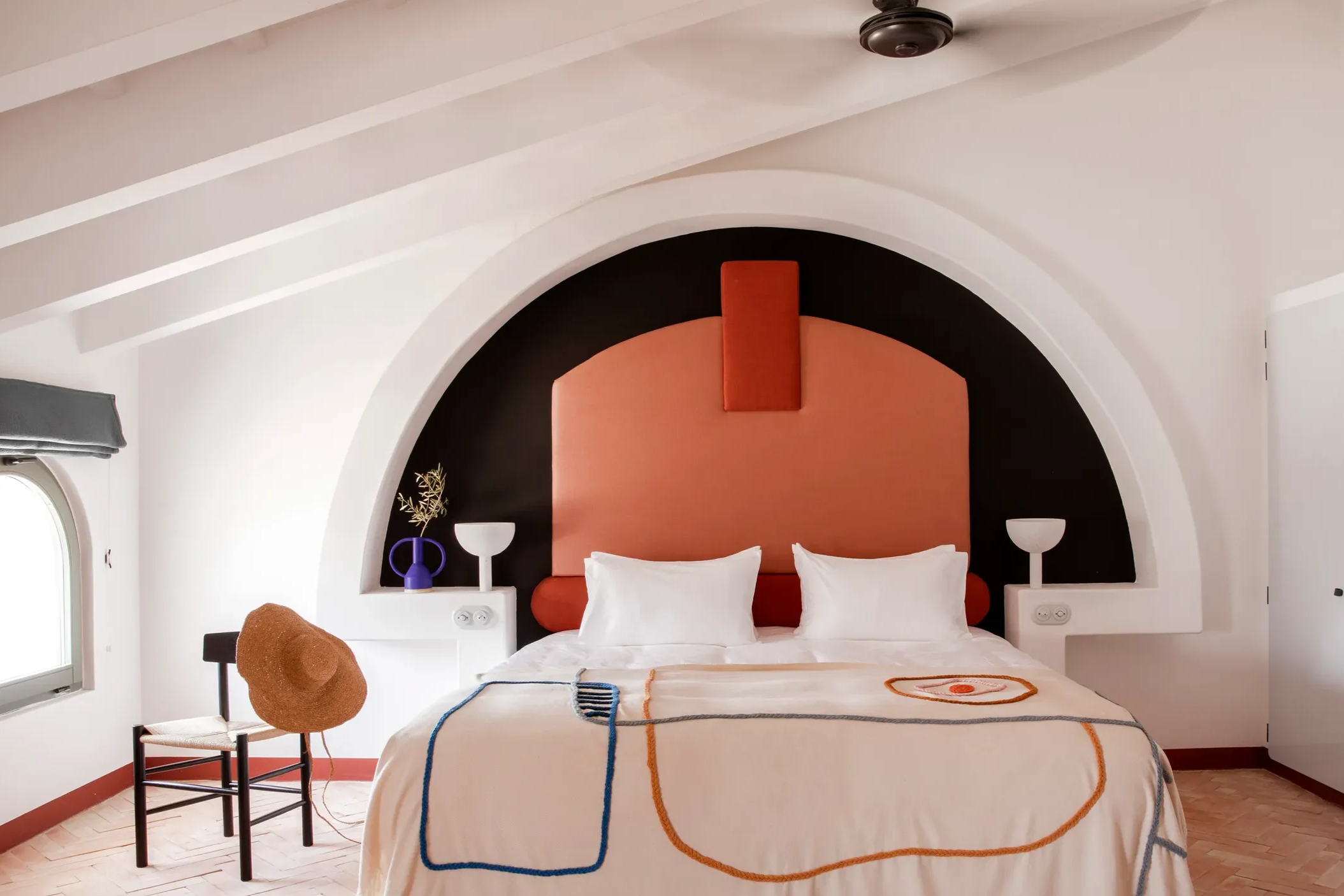Design-led bedroom at Menorca Experimental with terracotta headboard and Mediterranean interiors.
