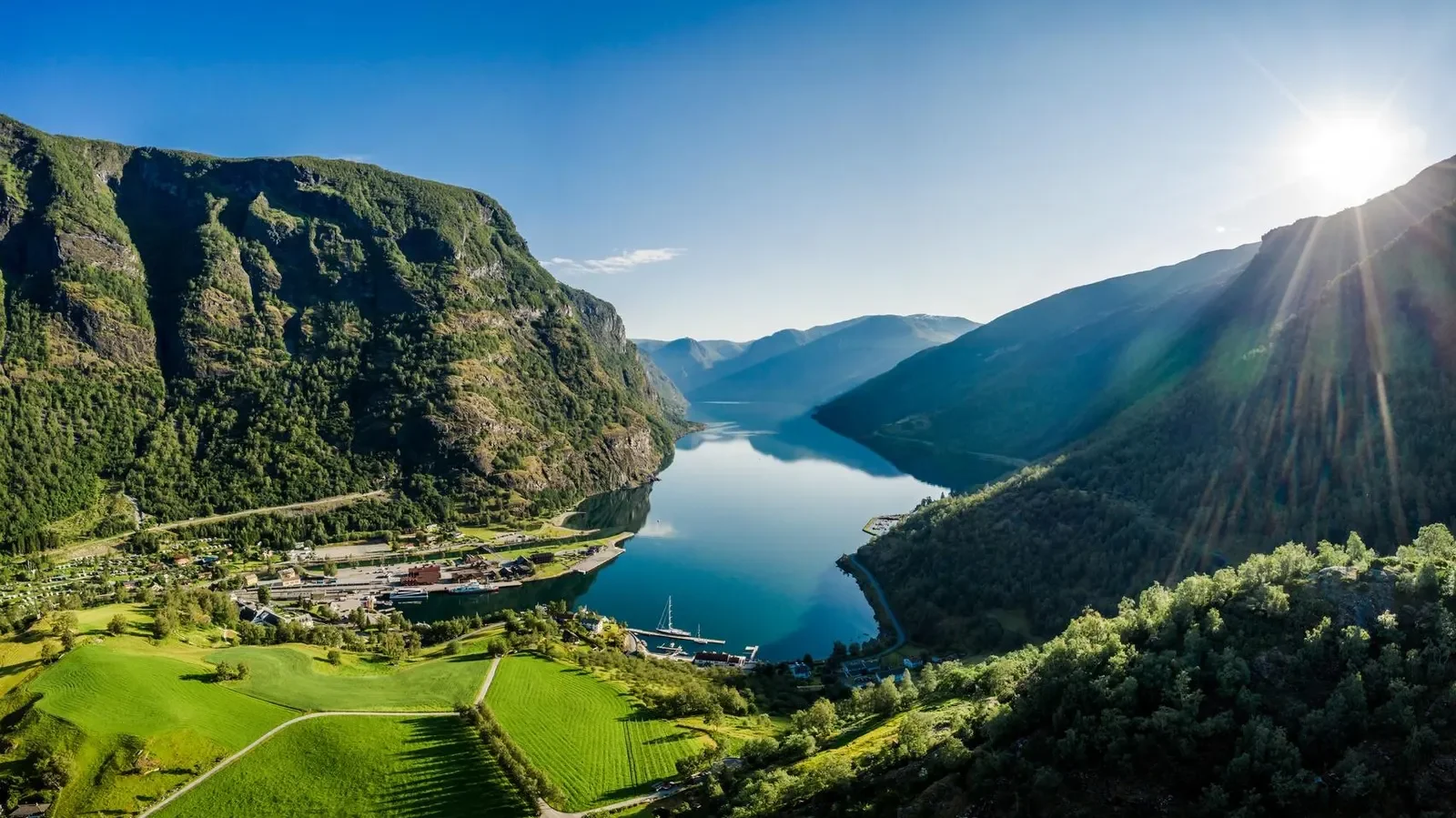 Dramatic Norwegian fjord landscape surrounded by mountains and summer sunlight