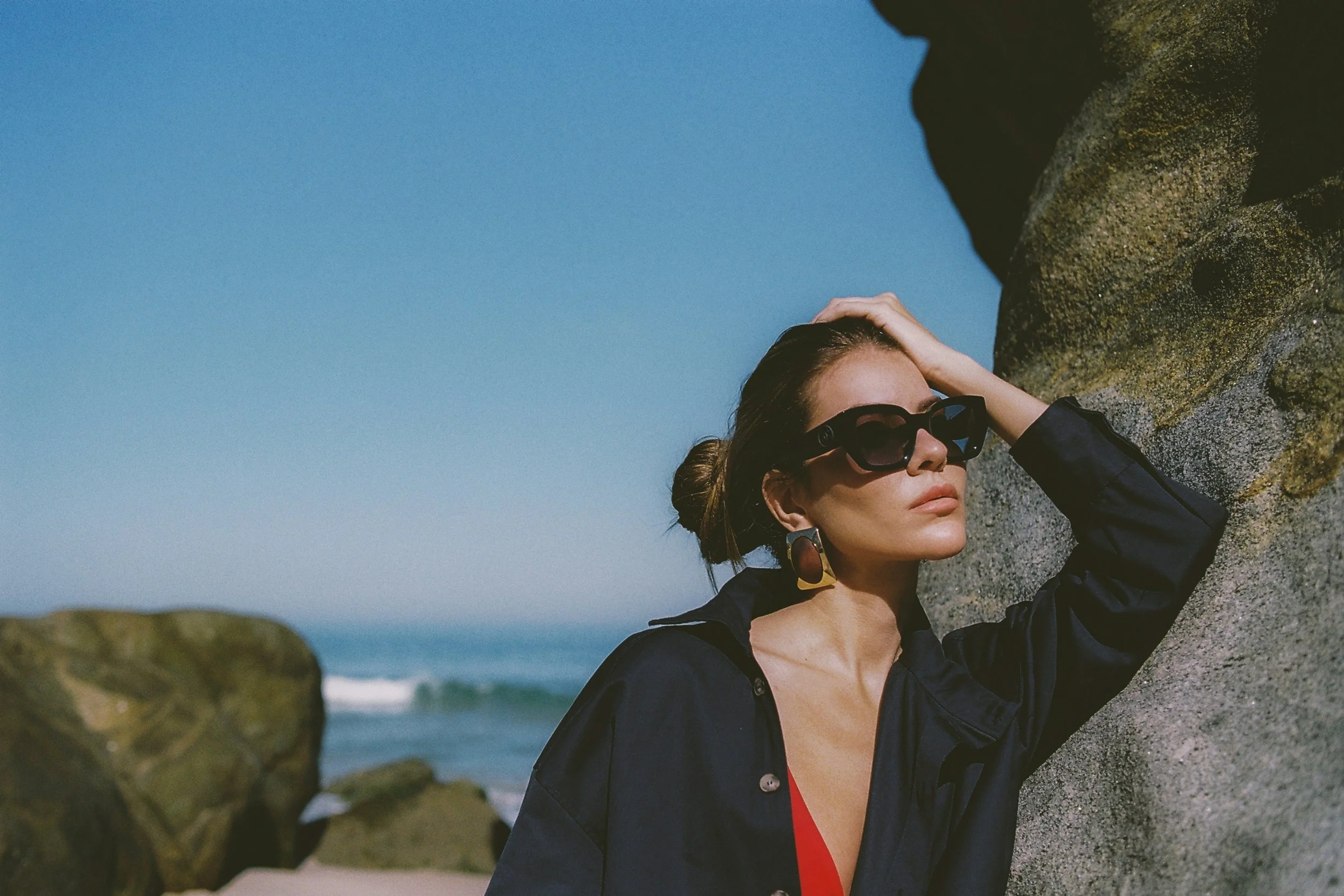 Woman in sunglasses on a beach showing how to achieve a sun-kissed glow without sun damage