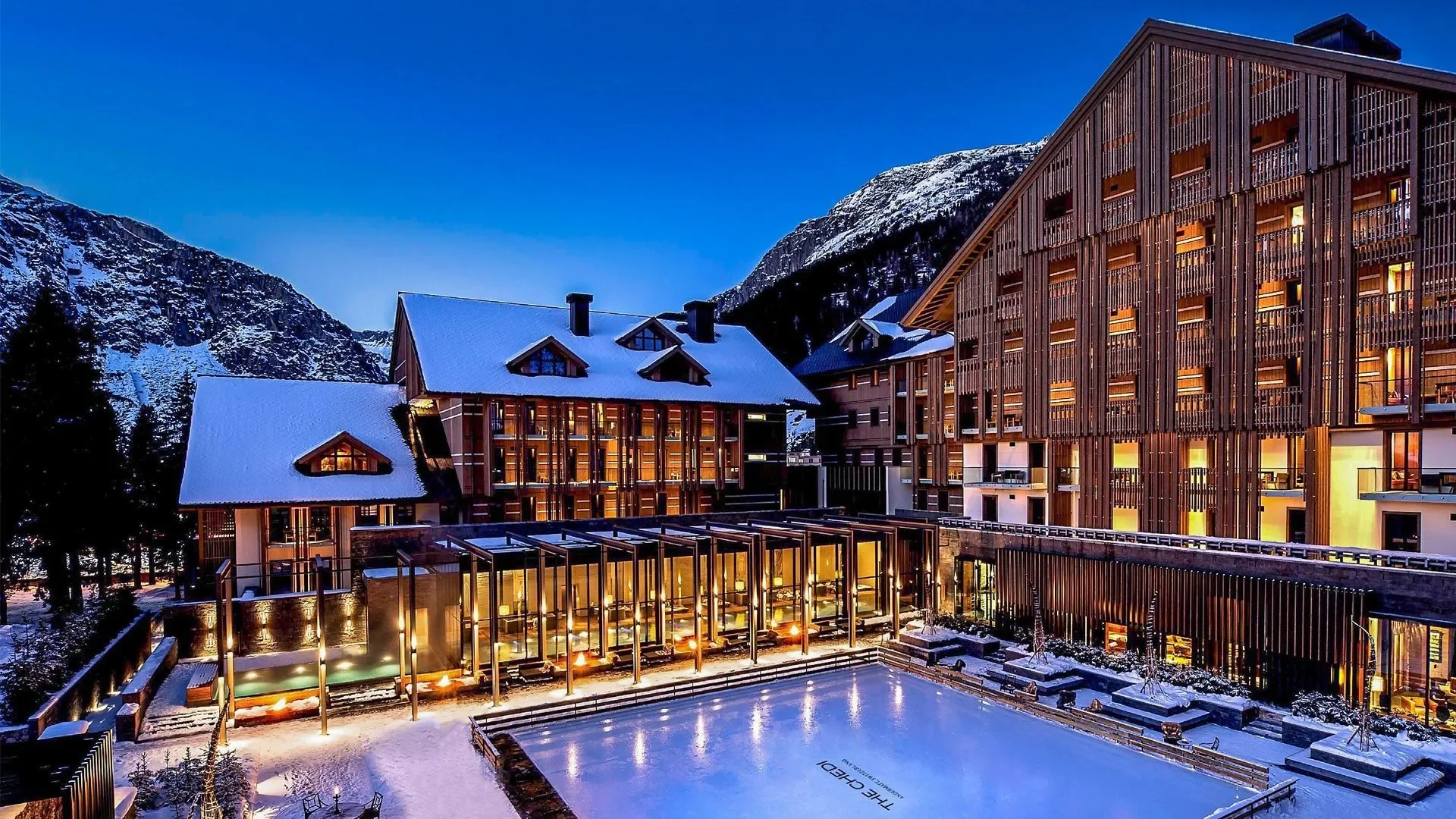 Snow covered hotel with outdoor swimming pool in the Alps at Switzlerland's The Chedi Hotel