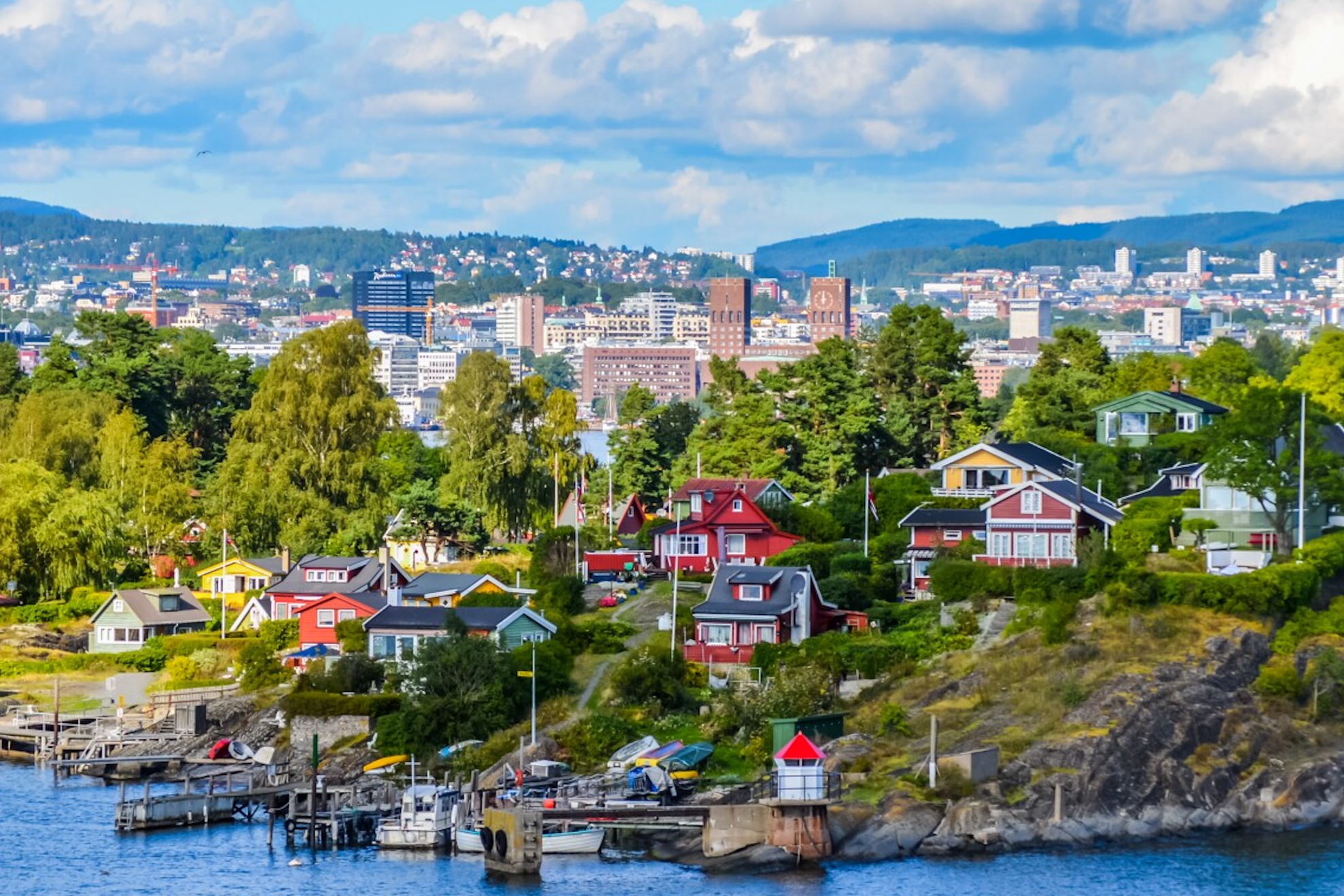 Summer view across Oslo with colourful houses and surrounding green hills