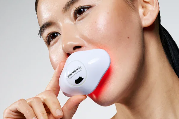 woman uses the CURRENTBODY Skin LED Lip Perfector £189 for plumper lips