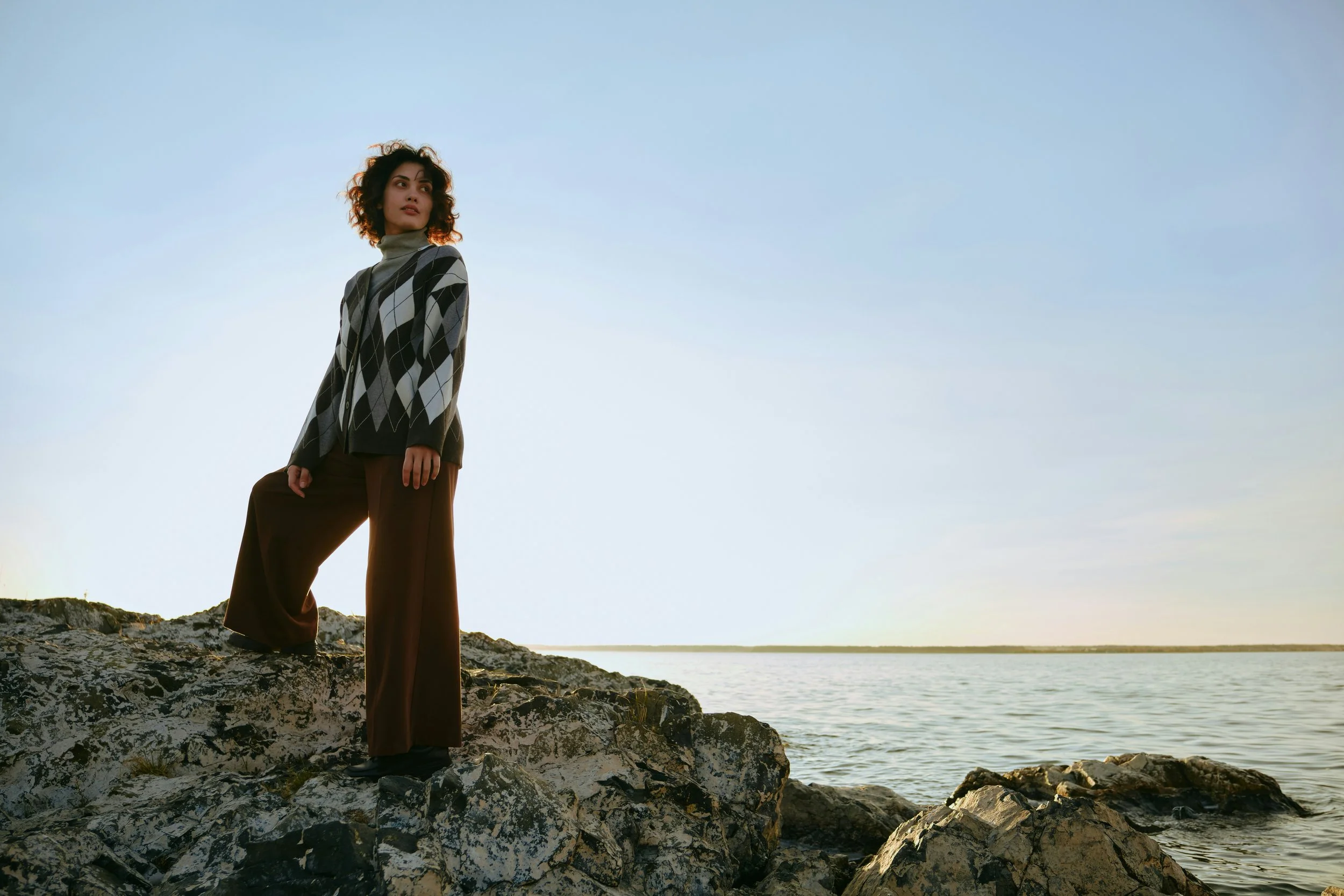 Woman standing by the sea, representing calm, perspective and long-term wellbeing