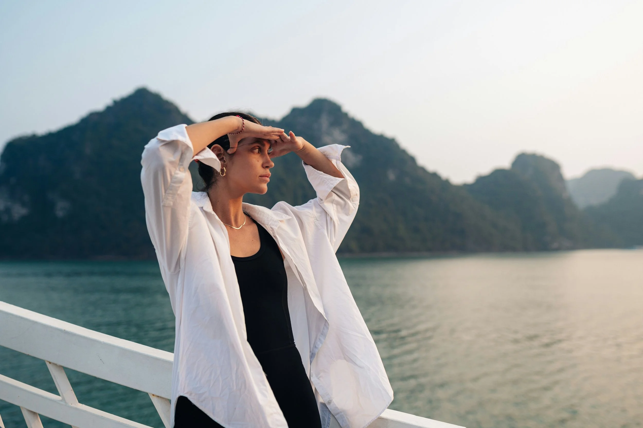 Woman shielding her eyes while looking out over water, reflecting on hormonal skin signals