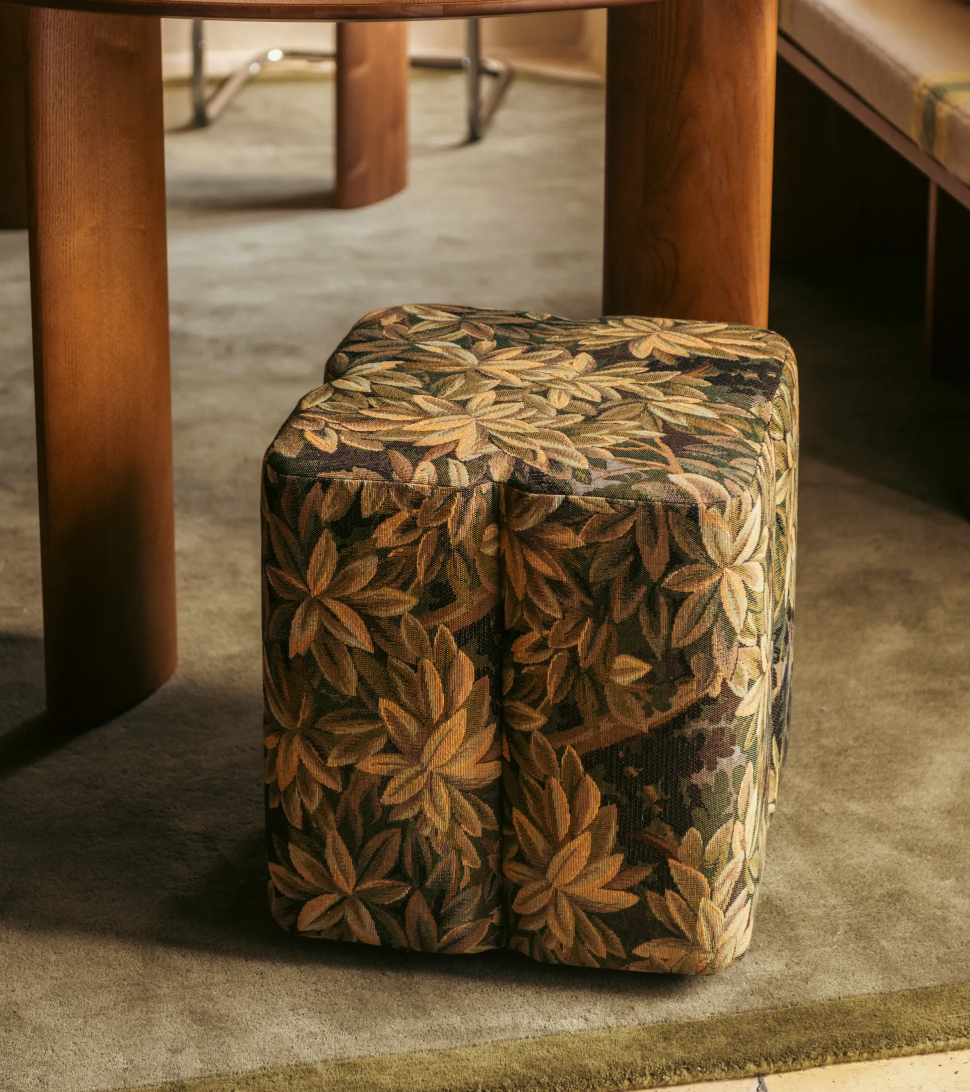 Curved structured pouf with patterned fabric, blending sculptural shape with soft edges for modern interior styling